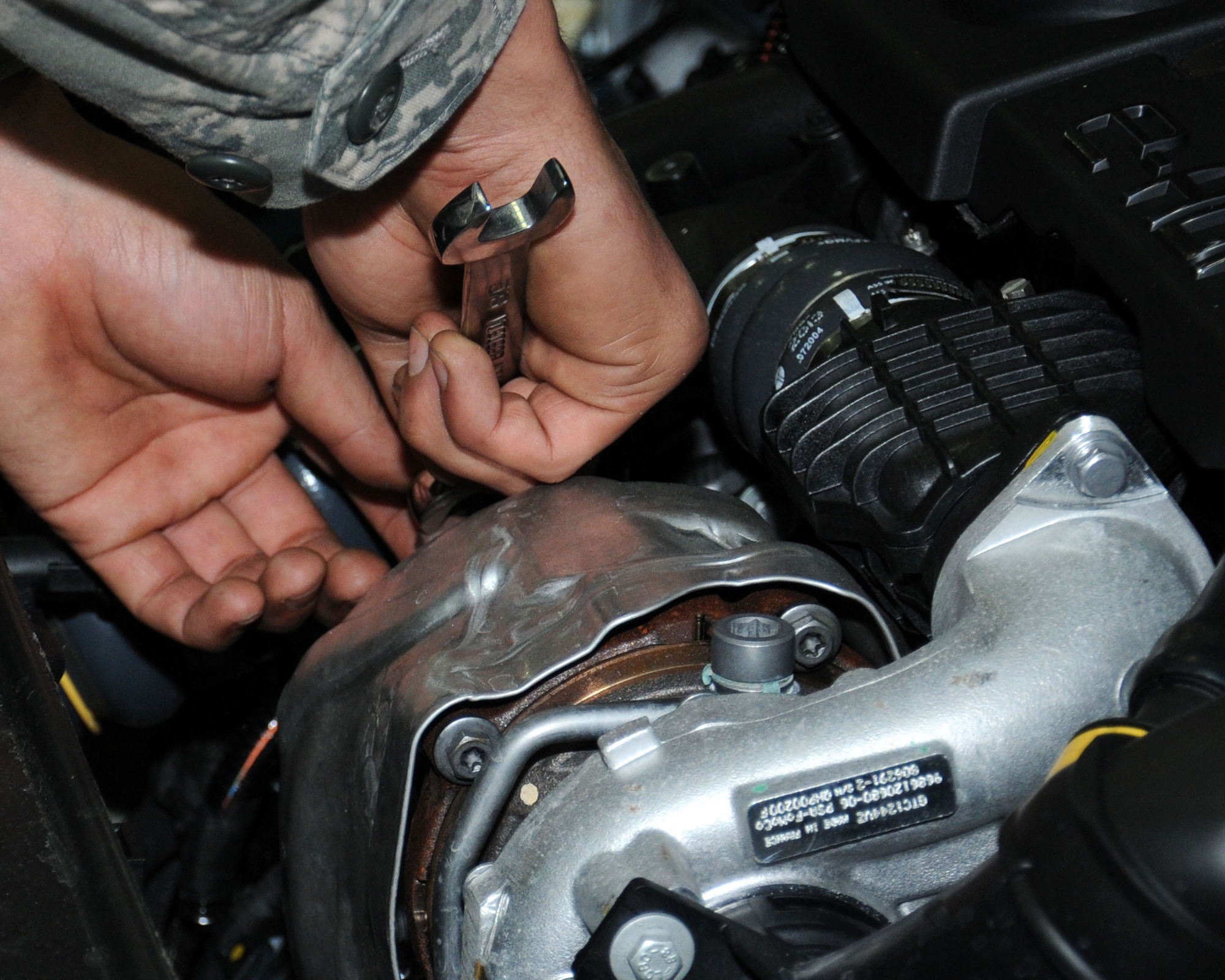 U.S. Air Force Airman 1st Class Jandreau Lance, 100th Logistics Readiness Squadron vehicle maintainer from Caribou, Maine, tightens a bolt Dec. 6, 2013, on the engine of a newly assigned low-carbon, fuel-efficient diesel sedan on RAF Mildenhall, England. The 100th LRS has replaced 19 vehicles with a newer more environmentally friendly fleet. This update optimizes the use of the vehicles and minimizes fuel consumption. (U.S. Air Force photo by Gina Randall/Released) 