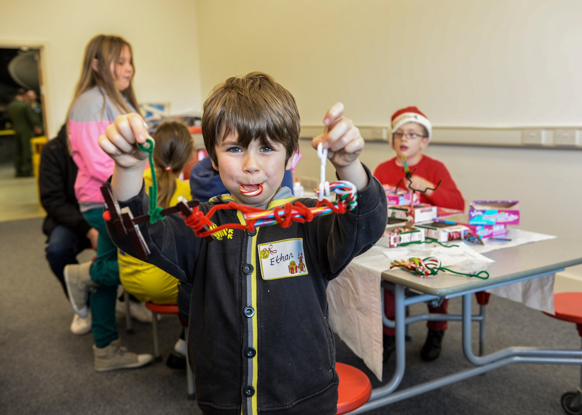 Ethan Goodchild, 8, displays one of his arts-and-crafts creations during the Duxford Christmas party at the Imperial War Museum Dec. 14, 2013. Established during World War II, the Duxford Christmas party was created by the Royal Air Force Duxford 78th Fighter Group to supply gifts and support to children from the London area who were orphaned by the war. (U.S Air Force photo by Airman 1st Class Nigel Sandridge/ Released)