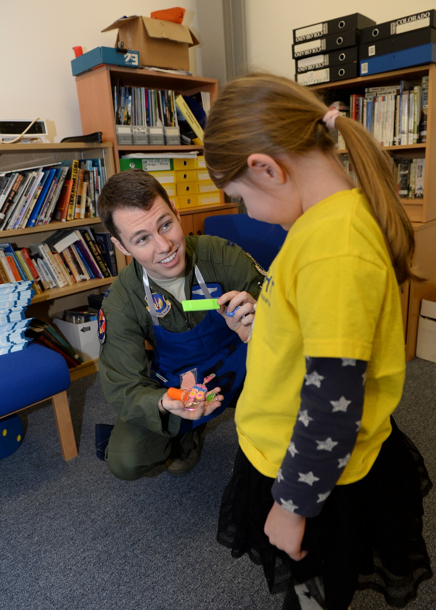 Capt. Jimmy Hayward, 492nd Fighter Squadron executive, awards a novelty toy to Kasey Machin, 6, after a game of ring toss during the Duxford Christmas party at the Imperial War Museum, Dec. 14, 2013. Established during World War II, the Duxford Christmas party was created by the Royal Air Force Duxford 78th Fighter Group to supply gifts and support to children from the London area who were orphaned by the war. (U.S Air Force photo by Airman 1st Class Nigel Sandridge/ Released)