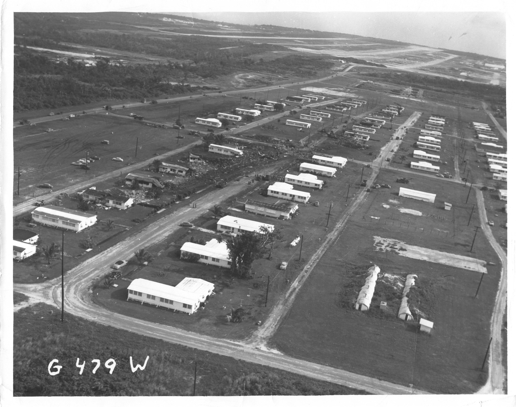 This Dec. 17, 1953, photo shows the path of destruction through the housing area.  The airfield runways can be seen in the distance towards the east.  Towards the end of the debris field the aircraft’s tail section is visible. (U.S. Air Force photo/Released)