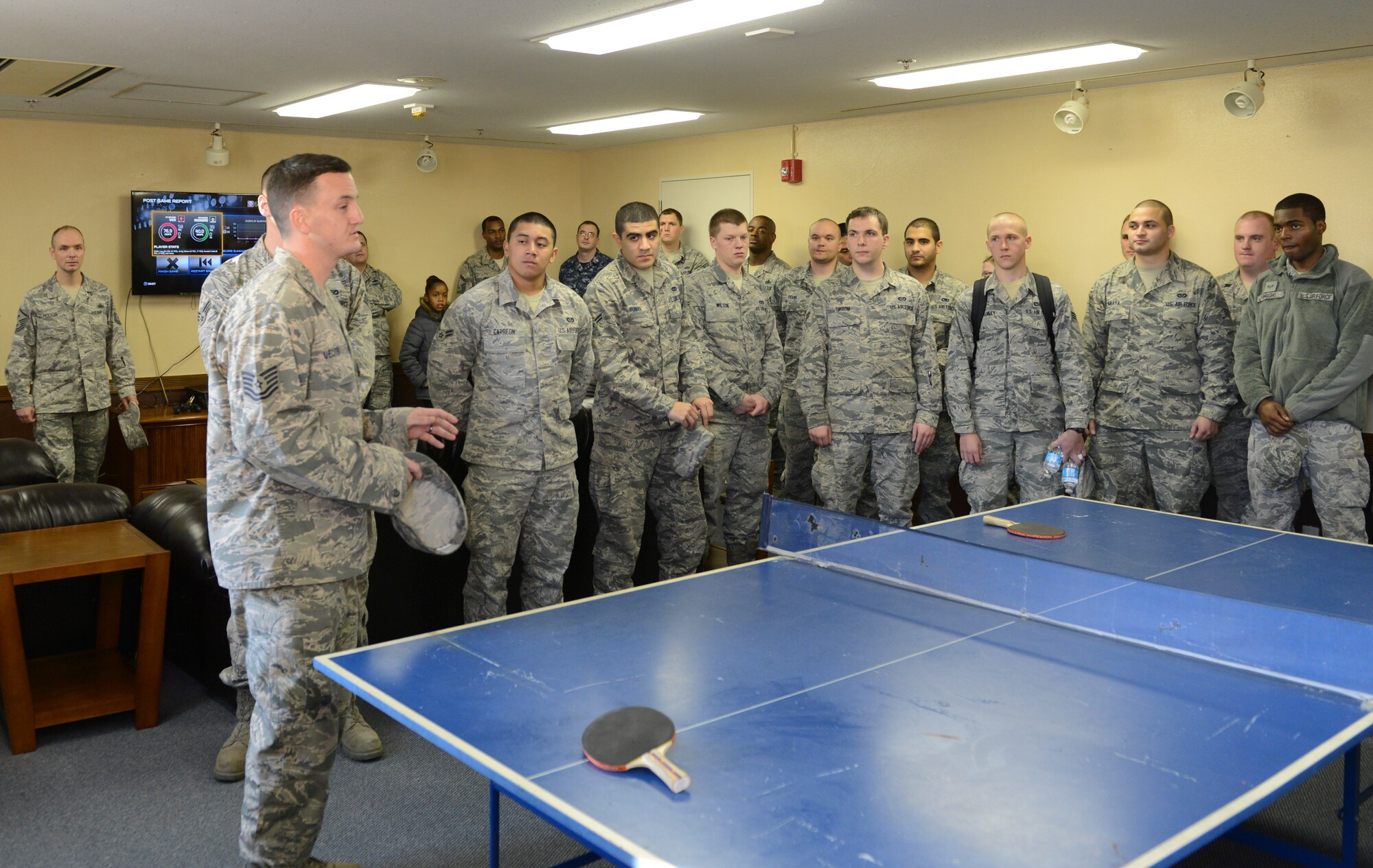 Tech. Sgt. Frank Uecher, 374th Civil Engineer Squadron housing maintenance section chief, talks to Airmen from dormitory building 208 after revealing a new refurbished dayroom at Yokota Air Base, Japan, Dec. 13, 2013. The amenities included new furniture, TV and PlayStation 4. (U.S. Air Force photo by Senior Airman Michael Washburn/Released)