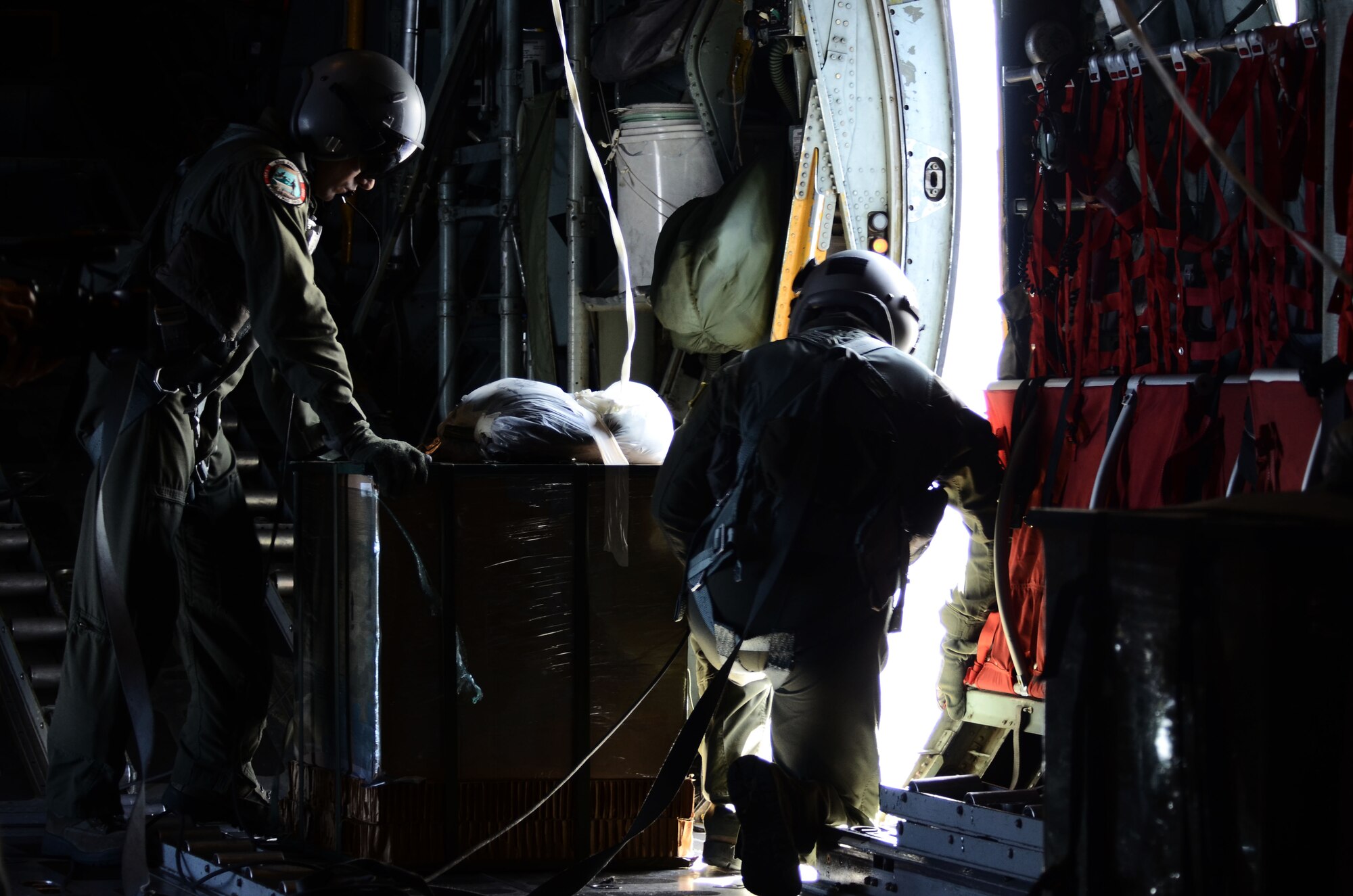 Staff Sergeants Ralph Oliver and Dmitri Sokgobenzon, loadmasters from the 36th Airlift Squadron, Yokota Air Base, Japan, prepare to airdrop packaged goods to islands in the Pacific as part of Operation Christmas Drop Dec. 14, 2013. This marks the 62nd year of Operation Christmas Drop, which began in 1952, making it the world’s longest running airdrop mission. (U.S. Air Force photo by Airman 1st Class Amanda Morris/ Released)