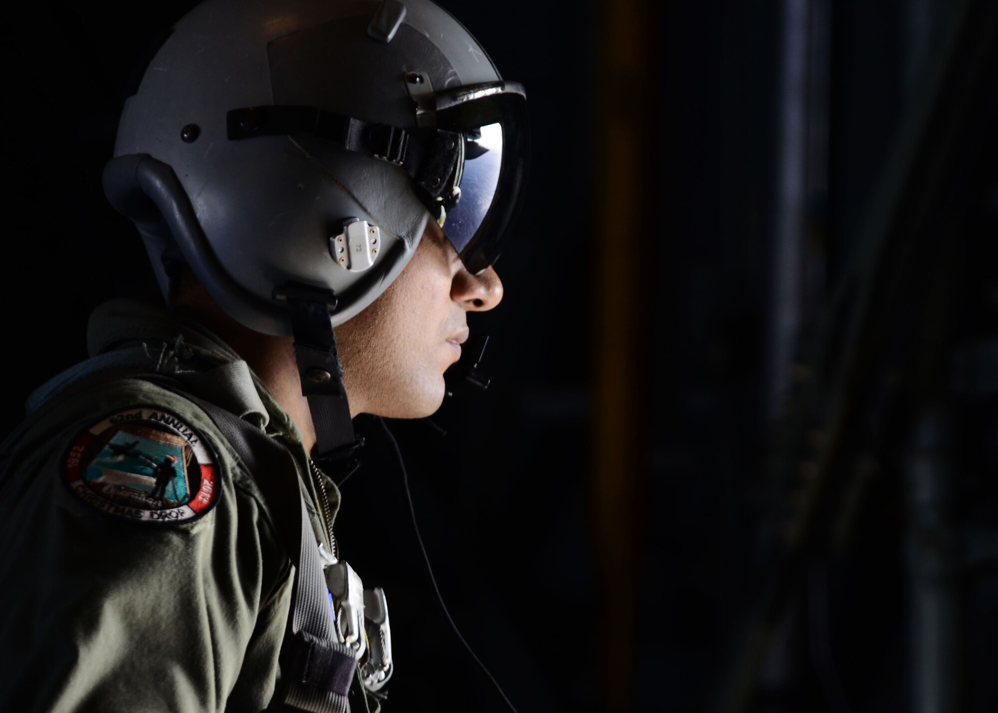 Staff Sgt. Ralph Oliver, loadmaster from the 36th Airlift Squadron, Yokota Air Base, Japan, overlooks islands in the Pacific as they prepare to airdrop packaged goods to the inhabitants Dec. 14, 2013 as part of Operation Christmas Drop. This marks the 62nd year of Operation Christmas Drop, which began in 1952, making it the world’s longest running airdrop mission. (U.S. Air Force photo by Airman 1st Class Amanda Morris/ Released)