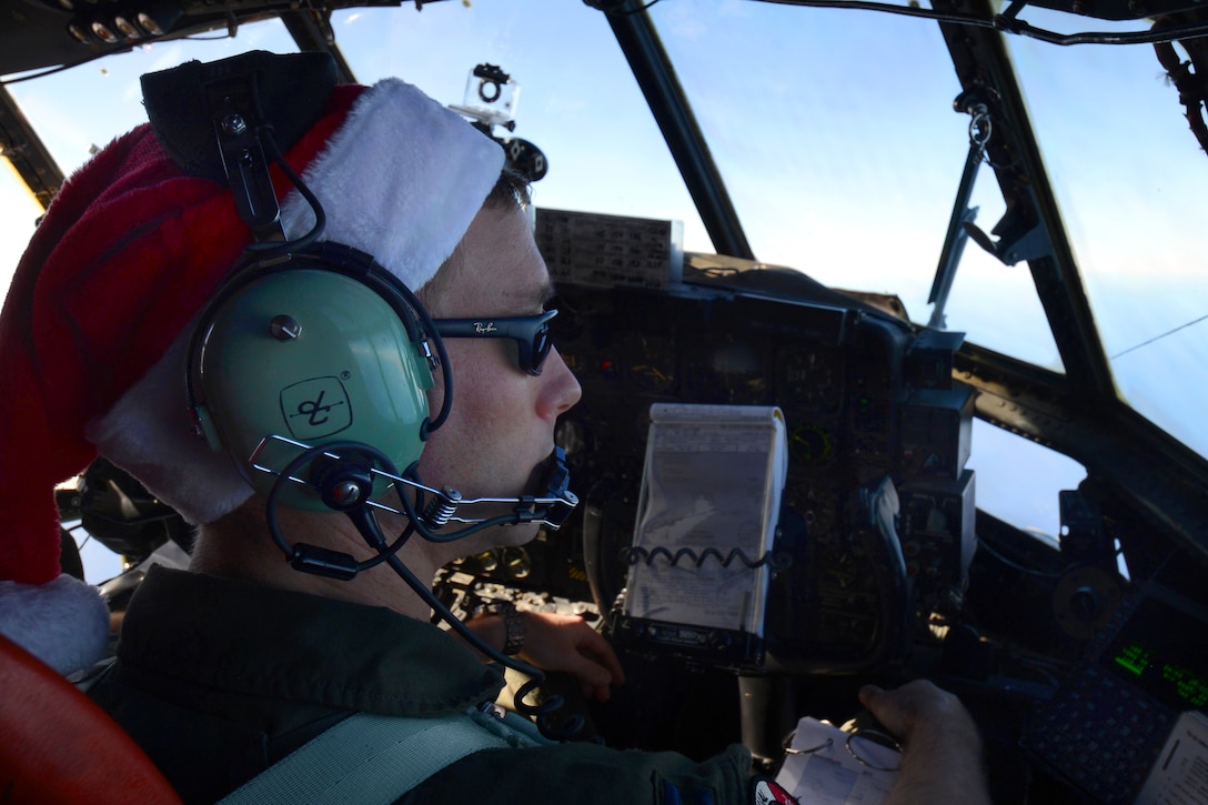 Air Force Capt. Mike Kelly searches for a red flag in the water marking the drop zone to air drop bundles during an Operation Christmas Drop mission over the Pacific Ocean, Dec. 11, 2013. Kelly, a pilot, is assigned to the 36th Airlift Squadron on Yokota Air Base, Japan. 