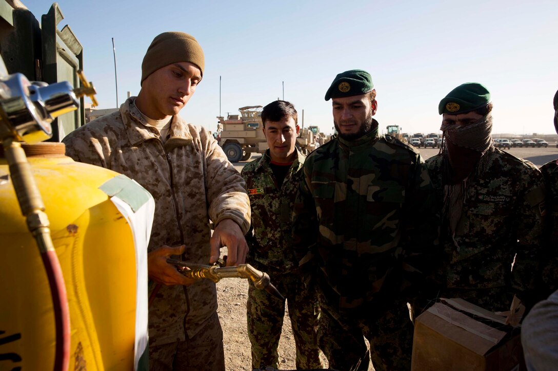 U.S. Marine Corps Luis Gonzales demonstrates how to use a welding torch ...