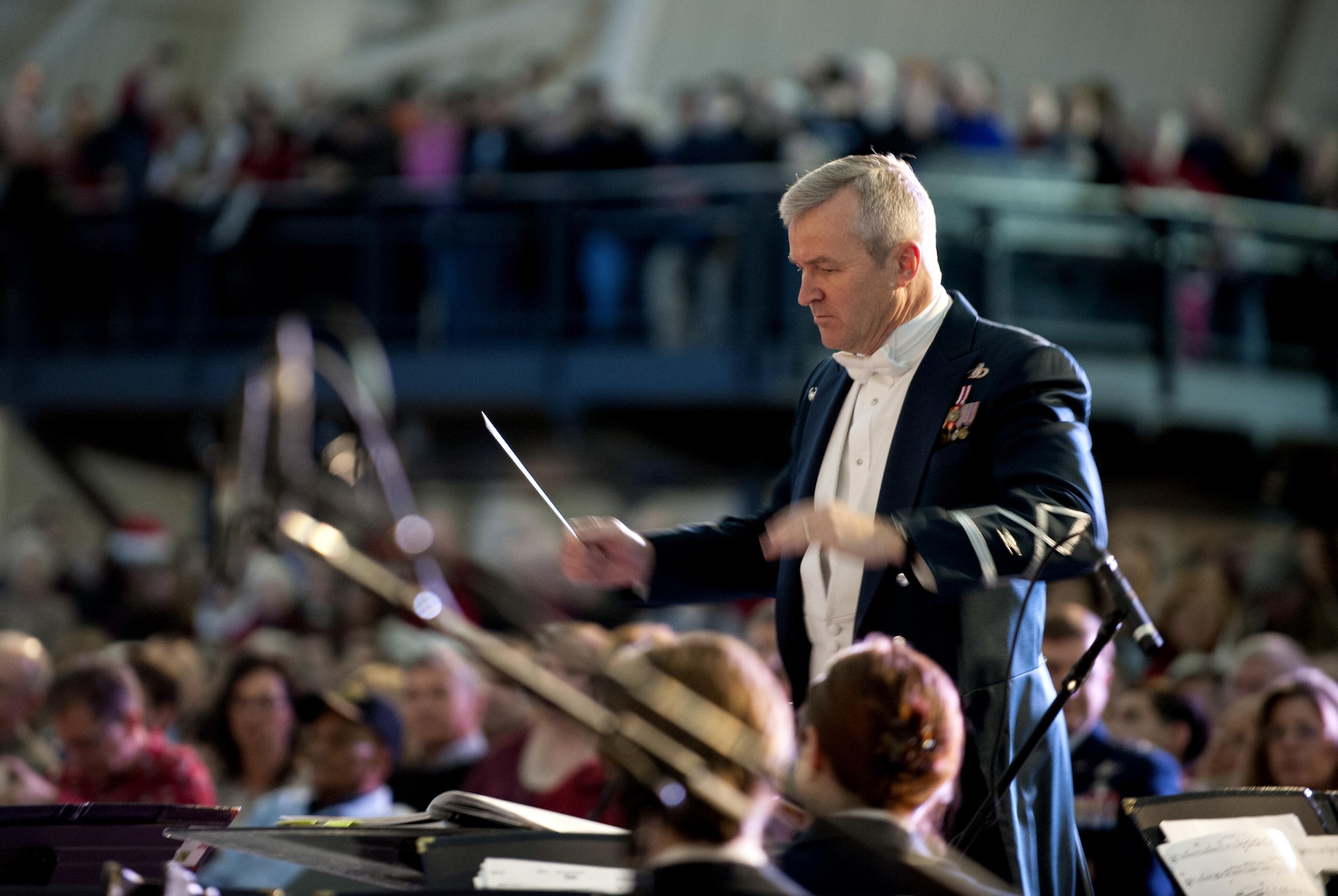 Col. Larry Lang conducts the U.S. Air Force Band during the “Spirit of the Season 2013” concert Dec. 15, 2013, at the Smithsonian National Air and Space Museum, Udvar-Hazy Center, Chantilly, Va. The band partnered with the Smithsonian Air and Space Museum to hold two performances for museum guests. Lang is the Air Force Band commander and conductor. (U.S. Air Force photo/Staff Sgt. Carlin Leslie)