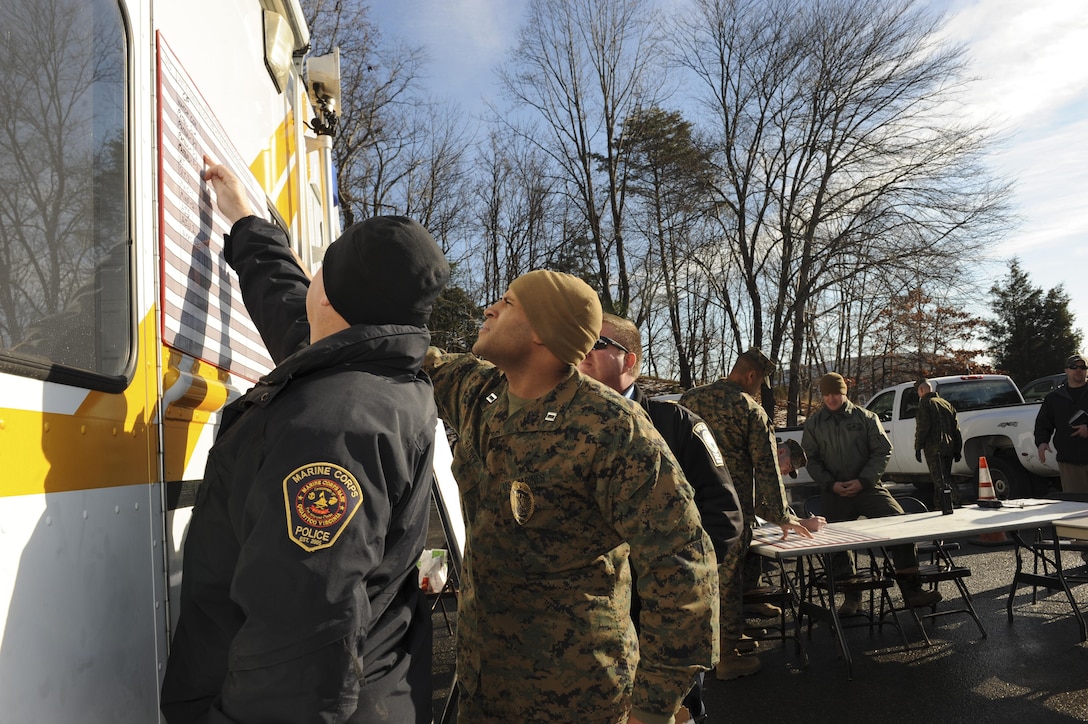 Capt. David Rainey, operations officer for Security Battalion, and other law enforcement officials review their plan during a training exercise Dec. 11, 2013, aboard Marine Corps Base Quantico.  The exercise was designed to give local jurisdictions a chance to simulate a unified response to a crisis. 