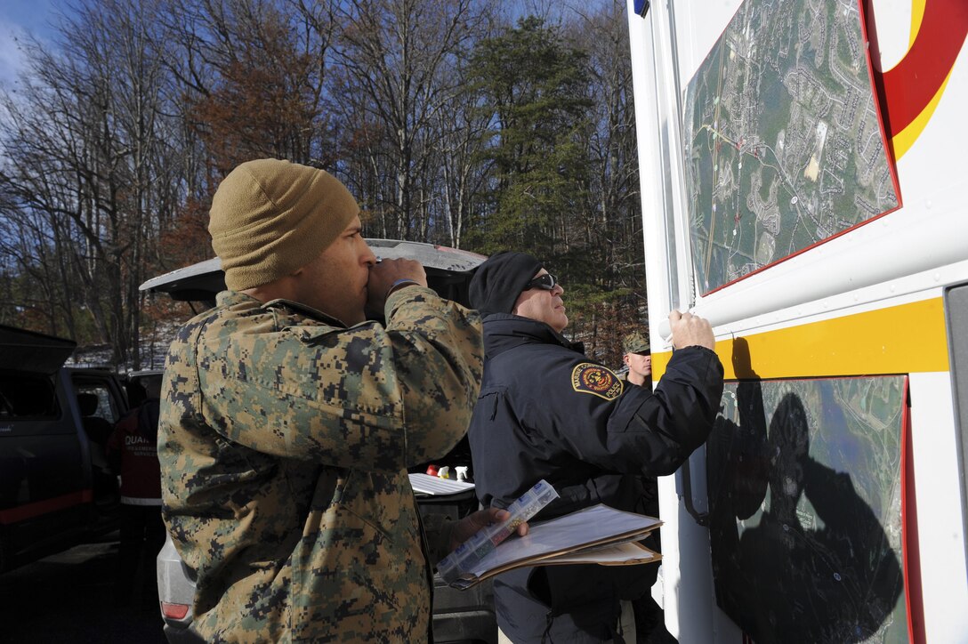 Capt. David Rainey, operations officer for Security Battalion, and other law enforcement officials map a plan during a training exercise Dec. 11, 2013, aboard Marine Corps Base Quantico.  The base Provost Marshal’s Office and fire/ emergency services, Prince William and Stafford Counties law enforcement and emergency agencies were among the agencies that participated in the event. 