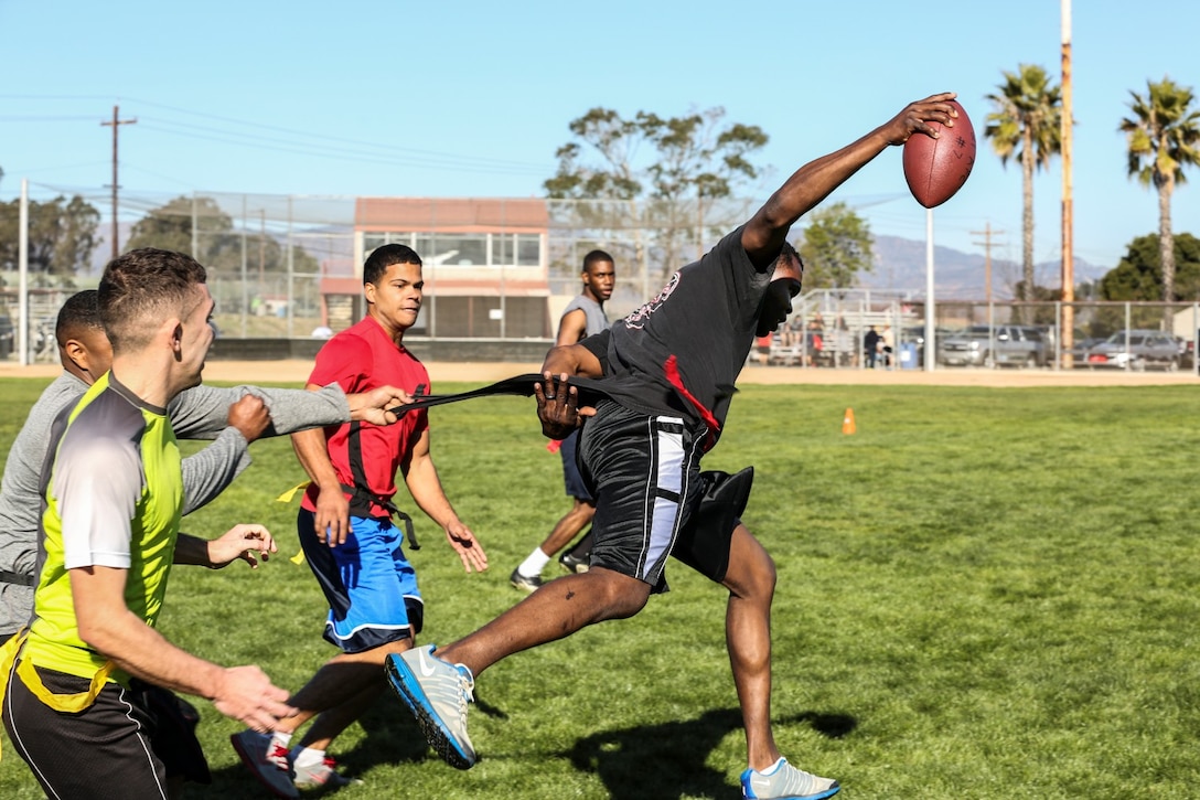 Sergeant Kenton A. Williams, motor transportation chief, 15th Marine Expeditionary Unit, breaks a tackle during a football game against Combat Logistics Battalion 15 aboard Camp Pendleton, Calif., Dec. 13. The 15th MEU played to promote esprit de corps and camaraderie between both units. Williams, 28, is from Aurora, Colo. (U.S. Marine Corps photo by Cpl. Emmanuel Ramos/Released)