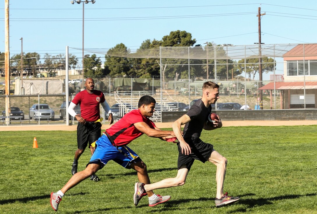 Lance Cpl. Taylor Bukoski, personal computer repairman, 15th Marine Expeditionary Unit, breaks a tackle during a football game against Combat Logistics Battalion 15 aboard Camp Pendleton, Calif., Dec. 13. The 15th MEU played to promote esprit de corps and camaraderie between both units. Bukoski, 21, is from Wanaque, N.J. (U.S. Marine Corps photo by Cpl. Emmanuel Ramos/Released)