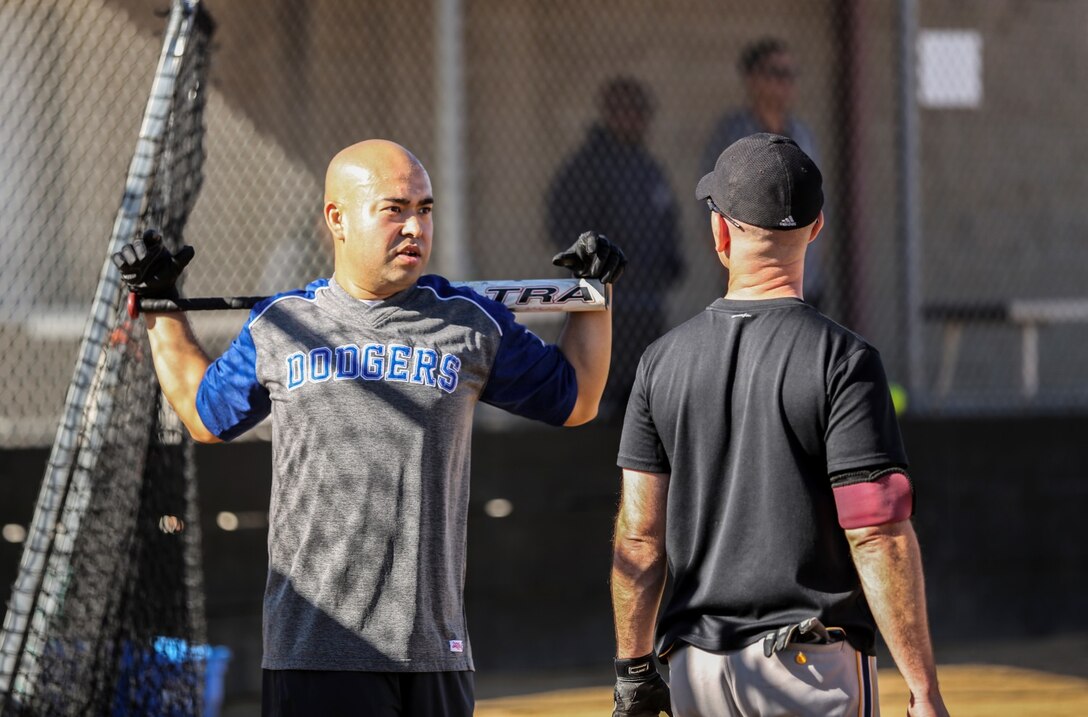 Staff Sgt. Miguel Carrasco, left, public affairs chief, stretches before going up to the plate during a softball game against Combat Logistics Battalion 15 aboard Camp Pendleton, Calif., Dec. 13. The 15th MEU played to promote esprit de corps and camaraderie between both units. (U.S. Marine Corps photo by Cpl. Emmanuel Ramos/Released)