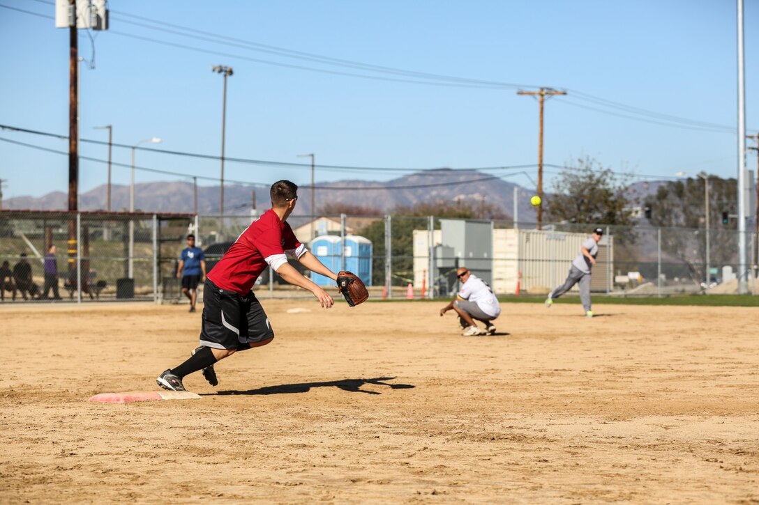Corporal Michael A. Travis, Marine Air-Ground Task Force planner, 15th Marine Expeditionary Unit, reaches for the ball during a softball game against Combat Logistics Battalion 15 aboard Camp Pendleton, Calif., Dec. 13. The 15th MEU played to promote esprit de corps and camaraderie between both units. Travis, 26, is from Talladega, Ala. (U.S. Marine Corps photo by Cpl. Emmanuel Ramos/Released)