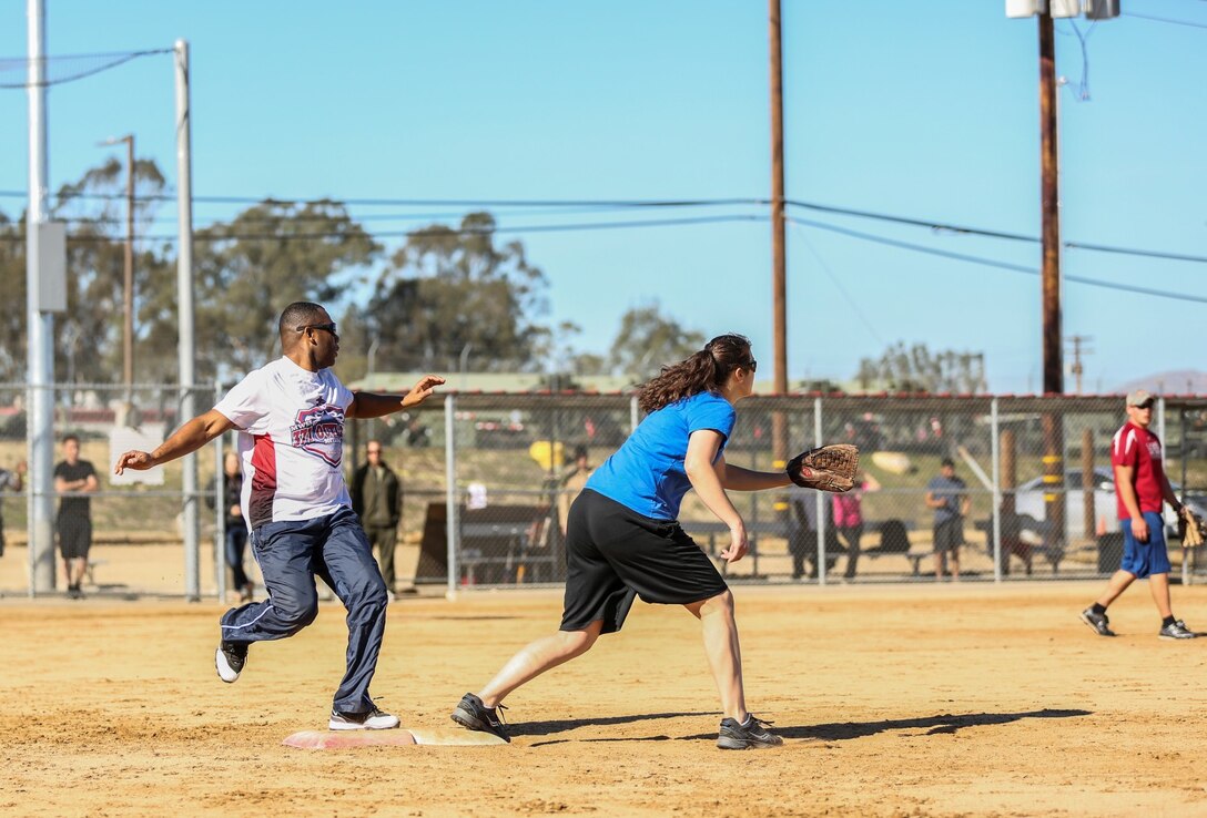 Sergeant Maj. John. W. Scott, left,  sergeant major, 15th Marine Expeditionary Unit, gets on first base during a softball game against Combat Logistics Battalion 15 aboard Camp Pendleton, Calif., Dec. 13. The 15th MEU played to promote esprit de corps and camaraderie between both units. (U.S. Marine Corps photo by Cpl. Emmanuel Ramos/Released)