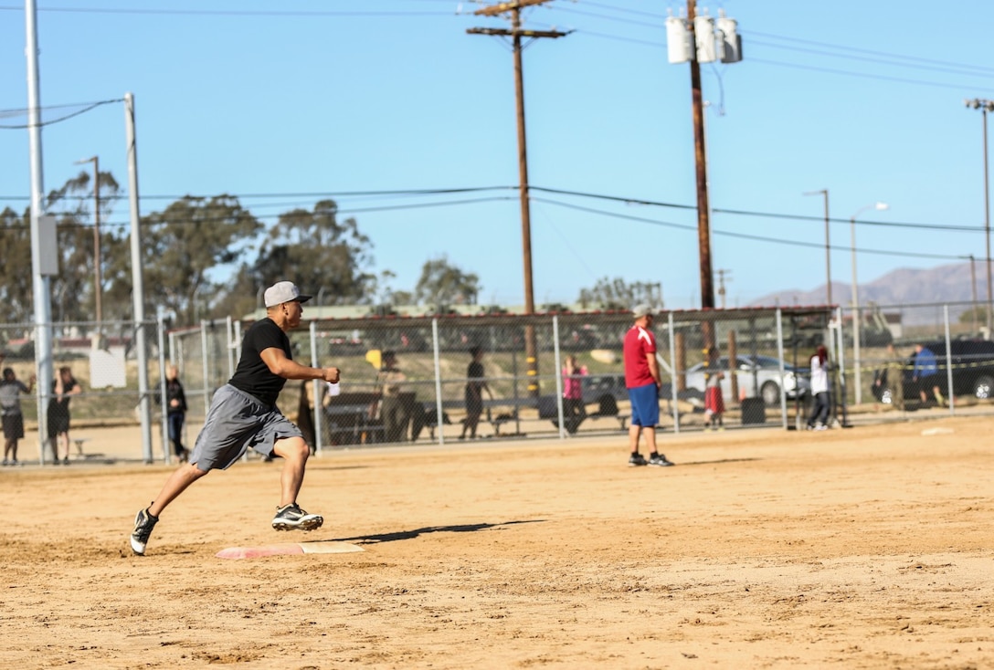 Corporal Jacob Martinez, administrative specialist, 15th Marine Expeditionary Unit, rounds first base during a softball game against Combat Logistics Battalion 15 aboard Camp Pendleton, Calif., Dec. 13. The 15th MEU played to promote esprit de corps and camaraderie between both units. Martinez, 24, is from Houston.(U.S. Marine Corps photo by Cpl. Emmanuel Ramos/Released)
