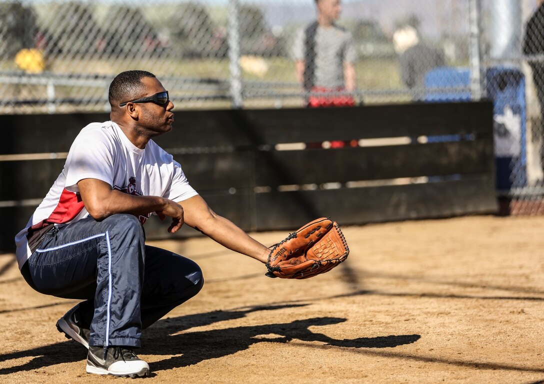 Sergeant Maj. John. W. Scott, sergeant major, 15th Marine Expeditionary Unit, plays catcher during a softball game against Combat Logistics Battalion 15 aboard Camp Pendleton, Calif., Dec. 13 The 15th MEU played to promote esprit de corps and camaraderie between both units. (U.S. Marine Corps photo by Cpl. Emmanuel Ramos/Released)