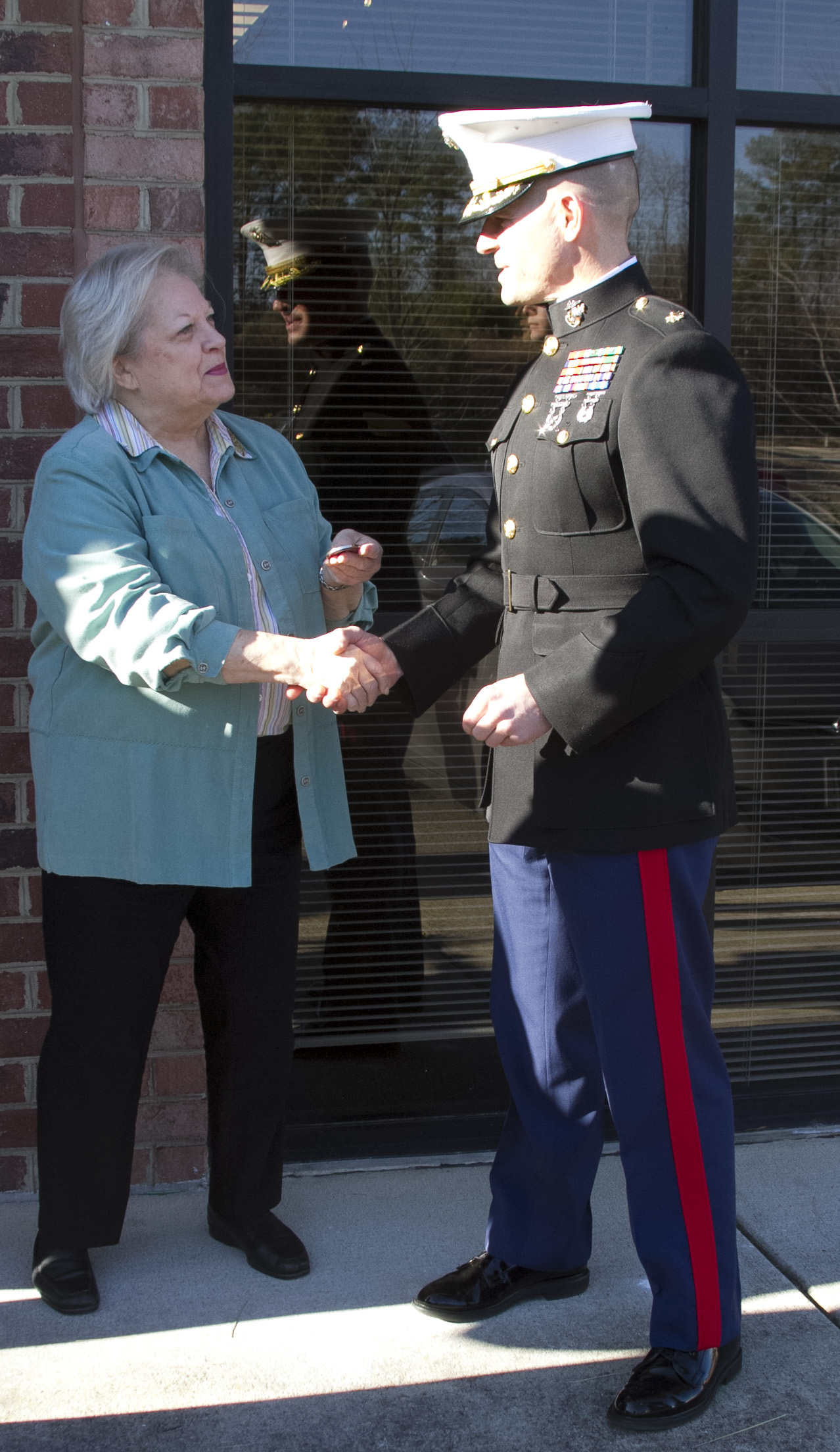 Marine Corps Maj. Brandon J. Gorman, the commanding officer of Marine Corps Recruiting Station Raleigh and Charlotte, N.C., native, presents Vivian Jones, the Mayor of Wake Forest, N.C., with a coin following the Permanent Contact Station Wake Forest grand opening ceremony in Wake Forest, N.C., on Dec. 16, 2013. The Marines held a grand opening featuring a ribbon cutting and Toys for Tots drive to promote the new station. (U.S. Marine Corps photo by Sgt. Dwight A. Henderson/Released) 