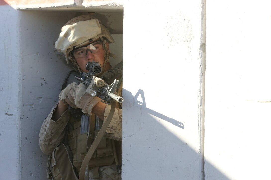 Private First Class Gregg Nelson, rifleman, Alpha Company, 1st Battalion, 7th Marine Regiment, and a native of Rochester, Minn., provides security during a live fire exercise on Range 210 at Marine Corps Air Ground Combat Center Twentynine Palms, Dec. 6, 2013. The facility resembles an urban environment and is unique because its buildings’ walls are constructed of shock-absorbent concrete. Unlike a majority of urban training facilities, Marines are able to conduct live fire training versus firing blank ammunition.