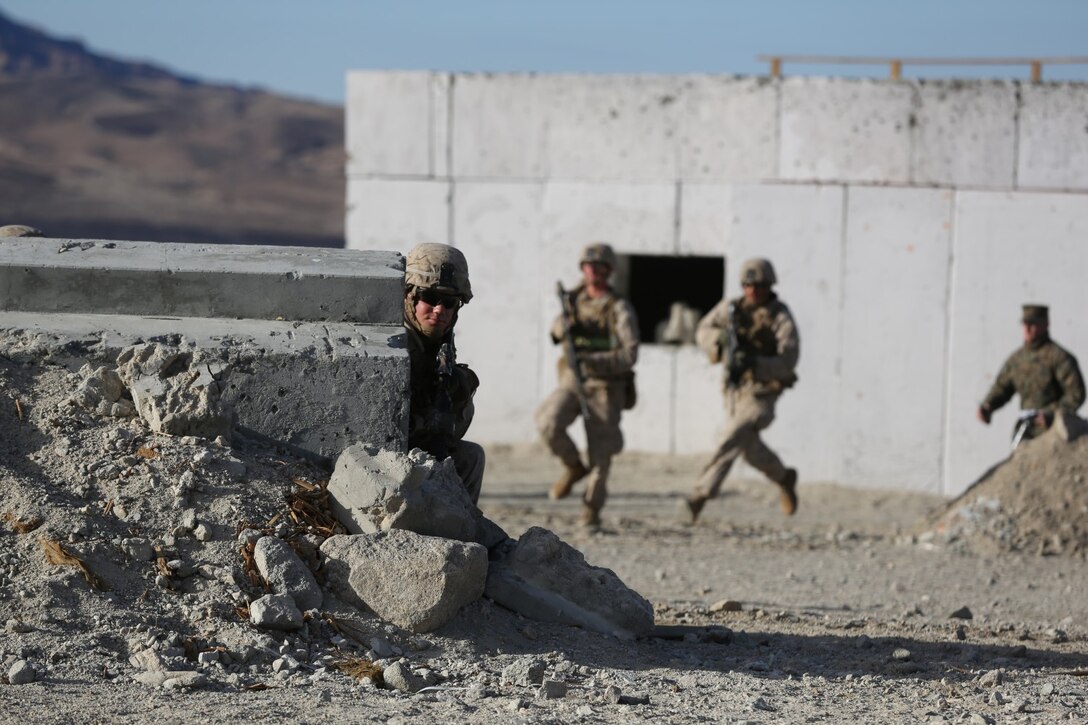 Lance Cpl. Michael Williamson, team leader, Alpha Company, 1st Battalion, 7th Marine Regiment, and a native of Prescott, Ariz., awaits for his team behind cover during a live fire exercise on Range 210 at Marine Corps Air Ground Combat Center Twentynine Palms, Dec. 6, 2013. Staff Sgt. Jeremiah Bergeron, a platoon sergeant with Alpha Co., said Range 210 is probably one of the most dynamic ranges in the Marine Corps and it does an excellent job of mimicking a combat environment.