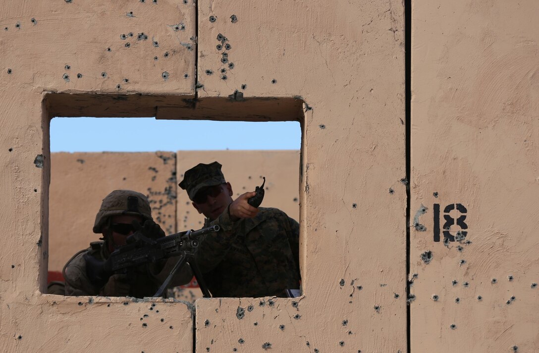 Lance Cpl. DeSean Pannel, rifleman, Alpha Company, 1st Battalion, 7th Marine Regiment, provides security while a Marine with 3rd Bn., 4th Marines, evaluates his performance during a live fire exercise on Range 210 at Marine Corps Air Ground Combat Center Twentynine Palms, Dec. 6, 2013. Staff Sgt. Jeremiah Bergeron, a platoon sergeant with Alpha Co., said Range 210 is probably one of the most dynamic ranges in the Marine Corps and it does an excellent job of mimicking a combat environment.