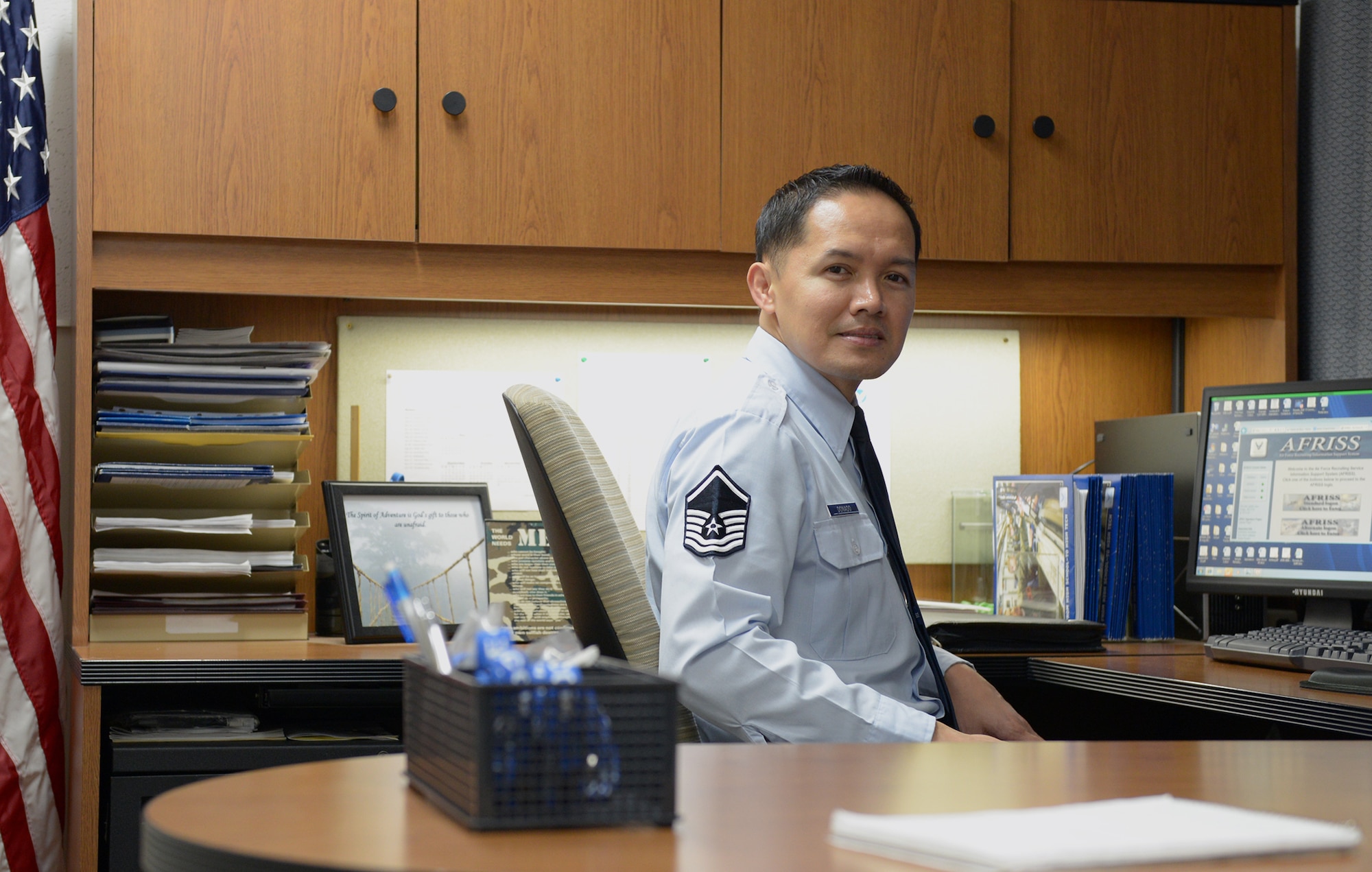 Master Sgt. Victor Donado Jr., 369th Air Force Recruiting Squadron Pacific enlisted accession recruiter, sits in his office at Yokota Air Base, Japan, Dec. 17, 2013. Donado has served as an Air Force recruiter for 11 years and has been stationed at Yokota since Aug. 2012. (U.S. Air Force photo by Airman 1st Class David Danford/Released)