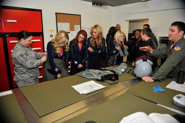 Members of the 36th Fighter Squadron showcase pieces of equipment pilots use during their flights to the Dallas Cowboys Cheerleaders during their holiday United Services Organization tour at Osan Air Base, Republic of Korea, Dec. 18, 2013. The cheerleaders also held a cheer clinic at the Osan High School. (U.S. Air Force photo/Staff Sgt. Emerson Nuñez)