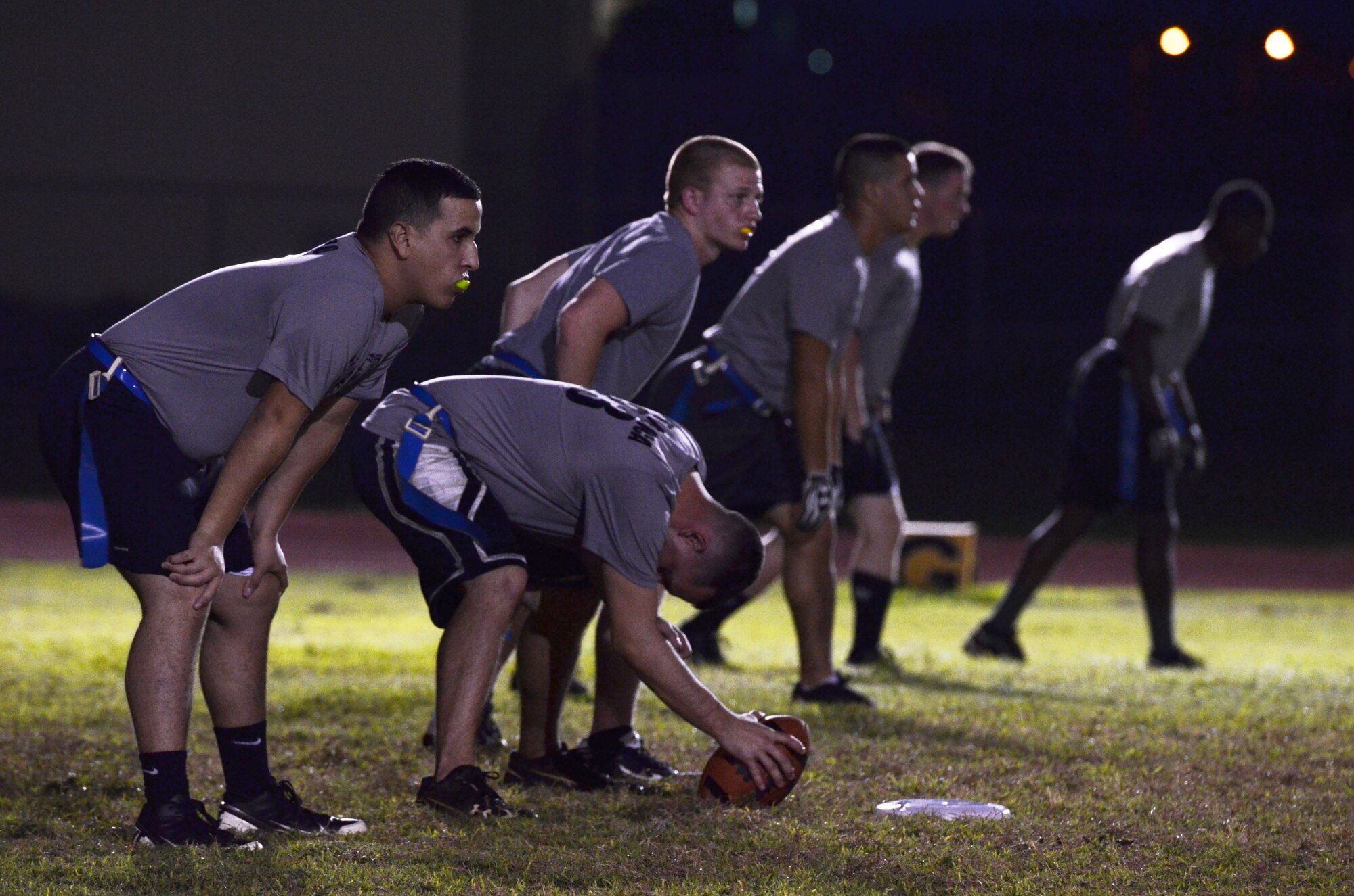 A player from the 36th Logistics Readiness Squadron prepares to hike the football during an intramural football game between 36th LRS and 36th Force Support Squadron on Andersen Air Force Base, Guam, Dec. 19, 2013. 36th FSS was defeated by 36th LRS 21-0. (U.S. Air Force photo by Airman 1st Class Mariah Haddenham/Released)