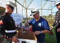 Senior Master Sgt. Guadalupe Ruiz, Pacific Air Forces/A4 manager, center, helps collect donated toys with “Toys for Tots” representatives, U.S. Marines Corps Lance Cpl. Doug Larrabee, left, and Lance Cpl. Brady Gilley, right, from the Heavy Marine Helicopter (HMH) 463, during the opening ceremonies for the 2nd Annual Super Draft Softball Tournament at Joint Base Pearl Harbor-Hickam, Hawaii, Dec. 14, 2013. The event was hosted by the AFSA and collected more than 70 toys for donations to “Toys for Tots.” (U.S. Air Force photo/Master Sgt. Jerome S. Tayborn)