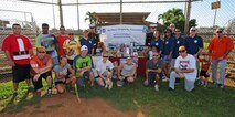 Volunteers and Joint Base Pearl Harbor-Hickam Air Force Sergeants Association members pose with U.S. Marines Corps “Toys for Tots” representatives for a group photo during the opening ceremonies of the 2nd Annual Super Draft Softball Tournament at the JBPHH, Hawaii, Dec. 14, 2013.  The event was hosted by the AFSA and collected more than 70 toys for donations to “Toys for Tots.” (U.S. Air Force photo/Master Sgt. Jerome S. Tayborn)