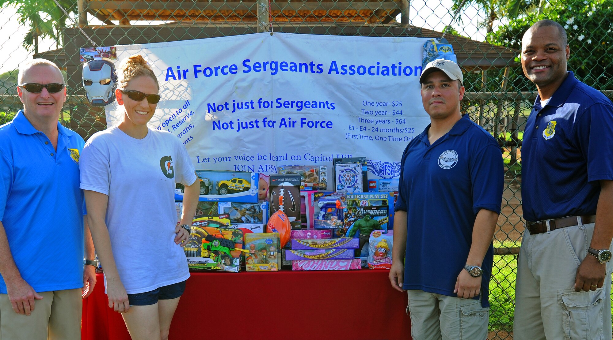 (From left to right) Col. Terry Scott, 15th Wing vice commander, Staff Sgt. Erin Frederick, 613th Air and Space Operations Center and event lead planner, Senior Master Sgt. Guadalupe Ruiz, Pacific Air Forces/A4 manager and Chief Master Sgt. Leslie Bramlett, 15th Wing command chief, pose for a group photo during the opening ceremony for the 2nd Annual Super Draft Softball Tournament in front of Joint Base Pearl Harbor-Hickam Air Force Sergeants Association donated toys, at JBPHH, Hawaii, Dec. 14, 2013.  (U.S. Air Force photo/Master Sgt. Jerome S. Tayborn)