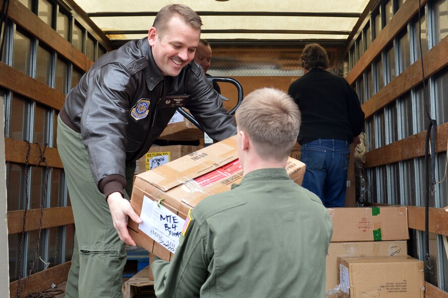 Volunteers unload boxes of donated electronic books and stuffed animals from the back of a delivery truck that is parked outside of the 4th Airlift Squadron Dec. 16, 2013, at Joint Base Lewis-McChord, Wash. The 4th AS is currently deployed to Southwest Asia and will be the first unit to receive a portion of the donated items. Deployed members will receive the electronic books and record themselves reading the stories to their children, prior to sending them home to their families. (U.S. Air Force photo/Staff Sgt. Jason Truskowski)