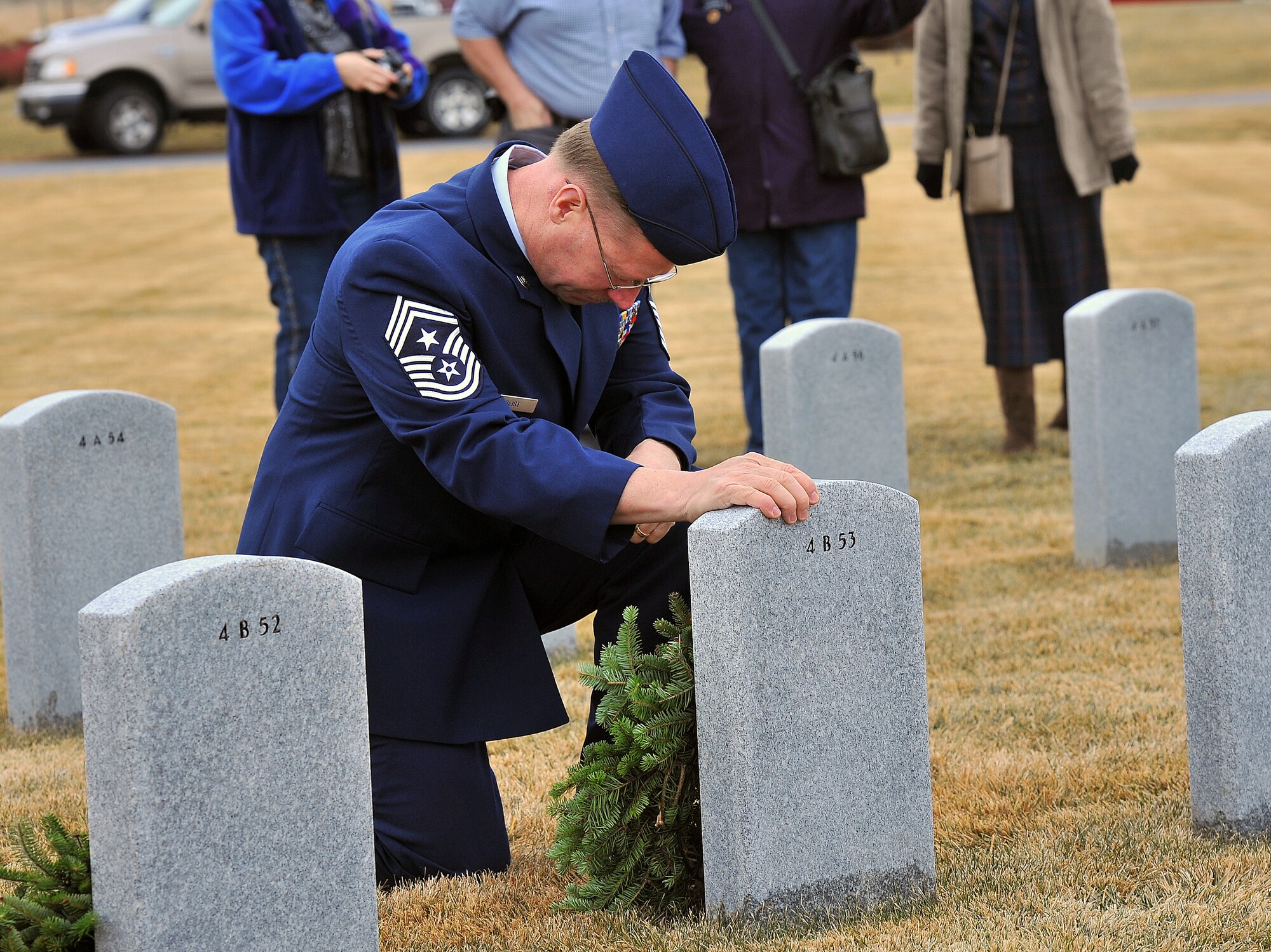 Chief Master Sgt. Wayne Deist, 141st Air Refueling Wing command chief, lays a wreath on a grave at the Washington State Veteran's Cemetery in Medical Lake, Wash., Dec. 14, 2013. The event is designed to spread the message about the importance of remembering fallen heroes, honoring those who served, and teaching children about the sacrifices made by veterans and their families to preserve freedom. (U.S. Air Force photo by Staff Sgt. Veronica Montes/Released)