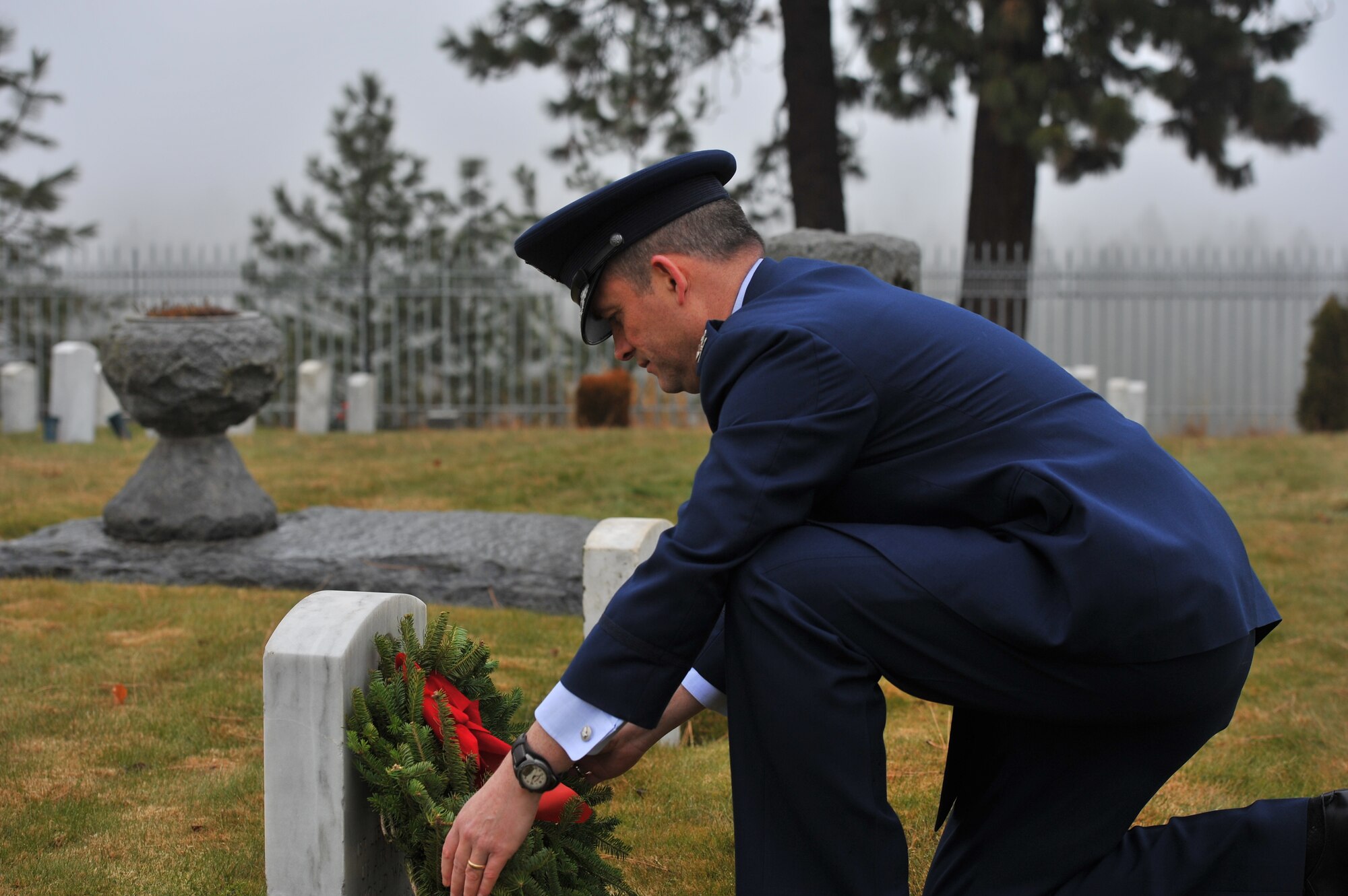 Col. Brian Newberry, 92nd Air Refueling Wing commander, places a wreath on a grave during Wreaths Across America at the Fort Wright Cemetery in Spokane, Wash., Dec. 14, 2013. The event is designed to spread the message about the importance of remembering fallen heroes, honoring those who served, and teaching children about the sacrifices made by veterans and their families to preserve freedom. (U.S. Air Force photo by Staff Sgt. Veronica Montes/Released)