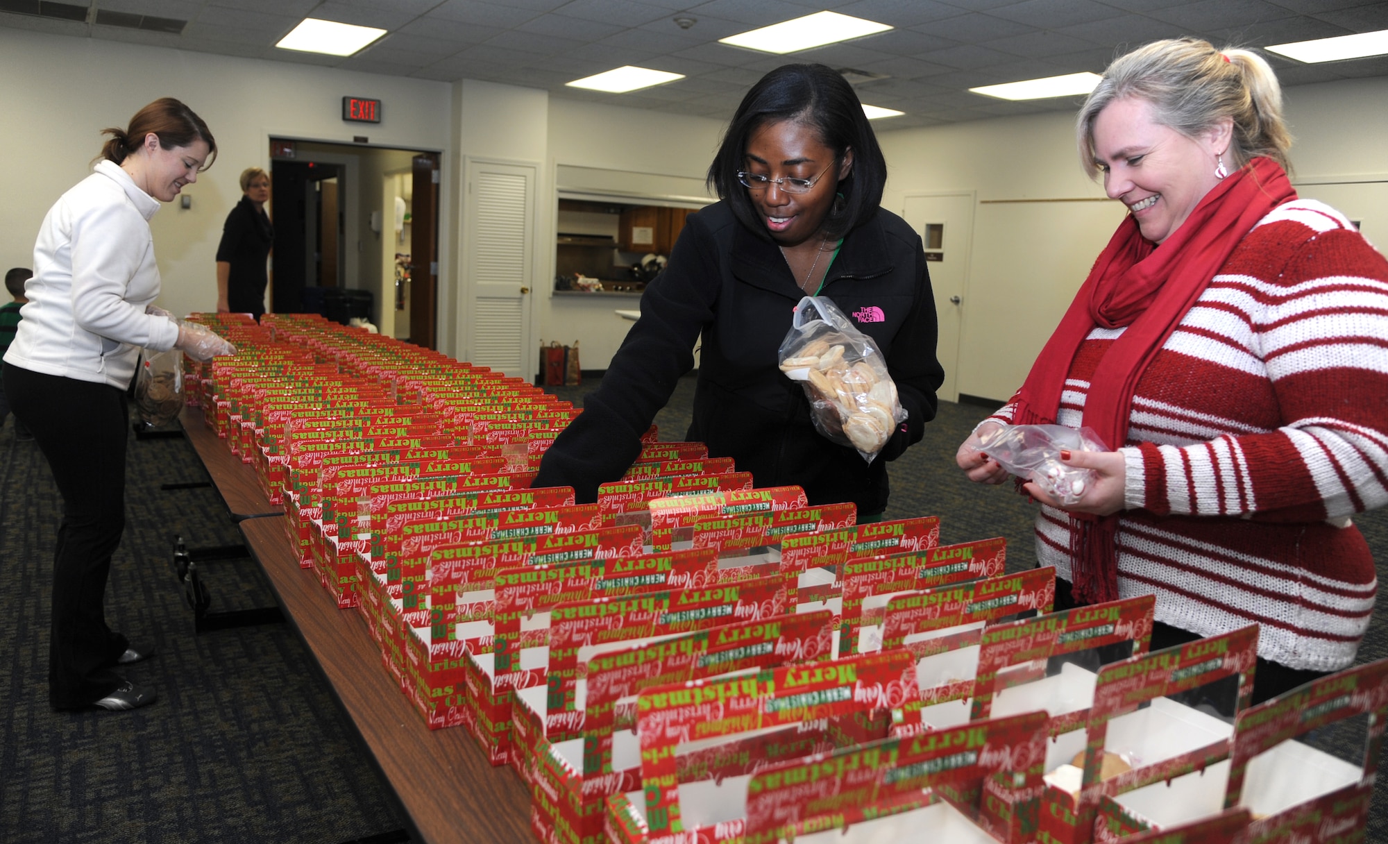 Officers’ Spouses’ Club members Denise Klohr, right, Shemia Morrow and Lauren Hottel, left, box cookies during the Airmen Cookie Drive held Dec. 18 in the Community Chapel Activity Center at Vance Air Force Base, Okla. (U.S. Air Force photo/ Senior Airman Frank Casciotta)