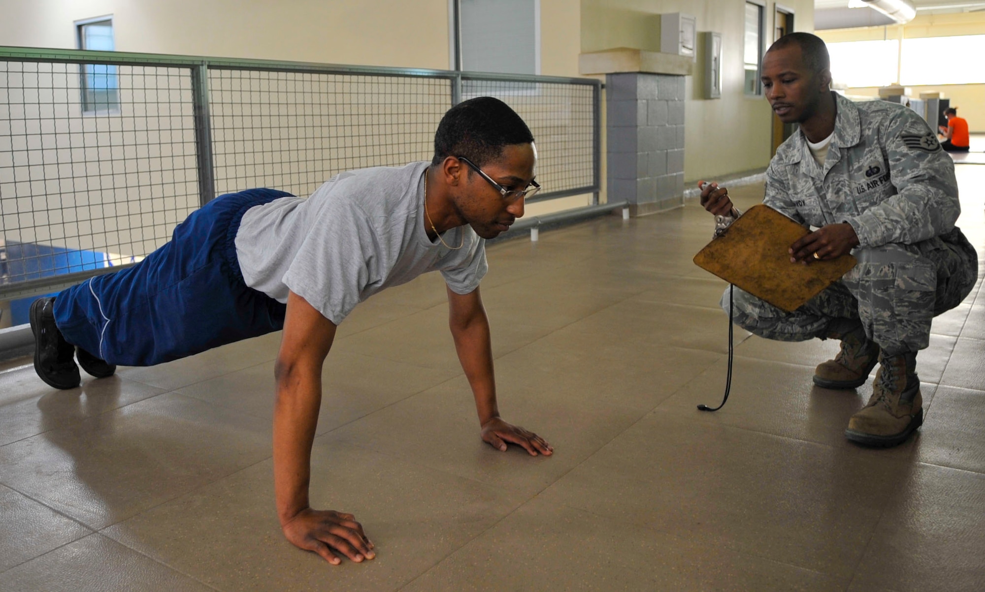 Staff Sgt. Derrick Savoy, Fitness Assessment Cell NCO in-charge watches the clock as Airman 1st Class  Michael Canady, 2nd Security Forces Squadron personnelist, does push-ups for one minute on Barksdale Air Force Base, La., Dec. 17, 2013. Beginning in January, the Health and Wellness Center will begin a new push-up and core-improvement class as part of the BE-WELL program to help Airmen who are struggling with low fitness assessment scores. (U.S. Air Force photo/ Airman 1st Class Benjamin Raughton)