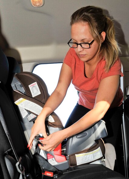 Katrina Pagan, a military spouse, correctly installs a car seat on Barksdale Air Force Base, La., Dec. 18, 2013. Car seats that are properly installed can reduce the risk of injury in the event of an automobile incident, and Barksdale has certified personnel available to assist with proper installation. (U.S. Air Force photo/ Airman 1st Class Benjamin Raughton)