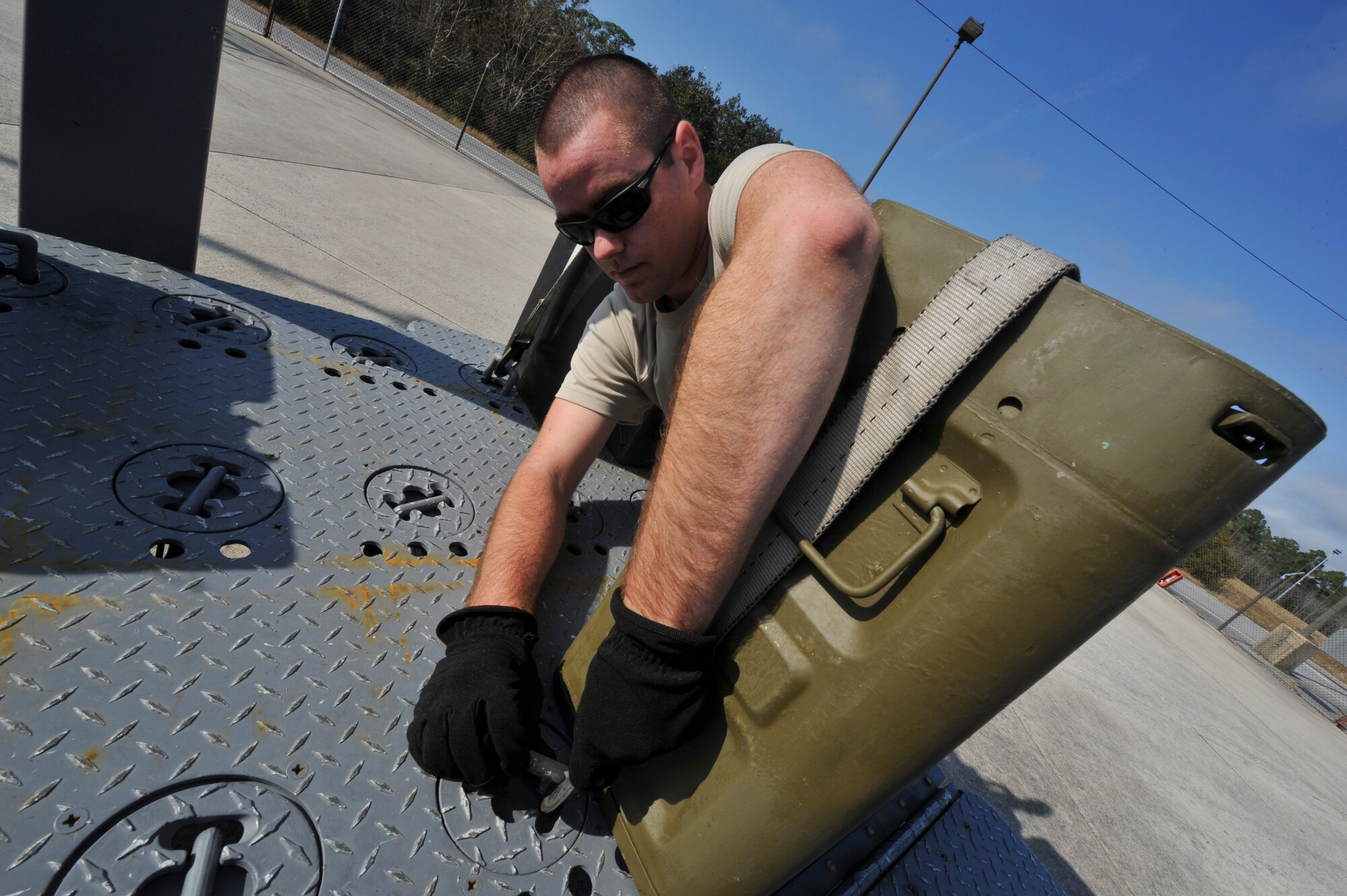 Senior Airman Patrick Beam, 1st Special Operations Equipment Maintenance Squadron munitions line delivery driver, secures a container of 40mm rounds to a munitions trailer on Hurlburt Field, Fla., Dec. 6, 2013. Line delivery drivers Properly secured containers to prevent damage during transport. (U.S. Air Force photo/Staff Sgt. John Bainter)