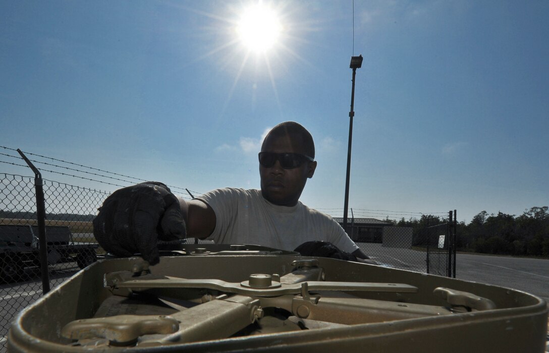 Senior Airman Marcus Montgomery, 1st Special Operations Equipment Maintenance Squadron munitions line delivery driver, removes the lid from a 40mm round container on Hurlburt Field, Fla., Dec. 6, 2013. The 40mm rounds come in several variations from armor piercing projectiles to highly explosive incendiary. (U.S. Air Force photo/Staff Sgt. John Bainter)
