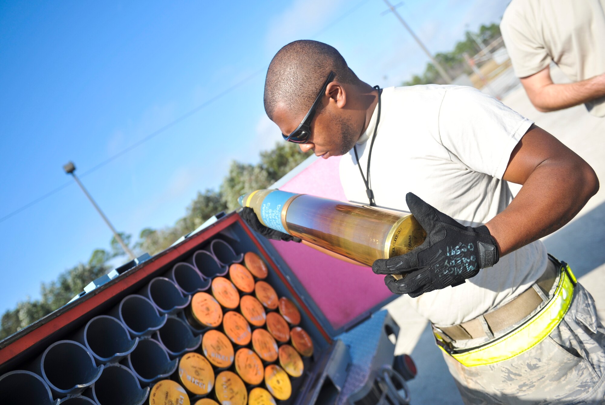 Senior Airman Marcus Montgomery, 1st Special Operations Equipment Maintenance Squadron munitions line delivery driver, inspects a 105mm round on Hurlburt Field, Fla., Dec. 6, 2013. Montgomery inspected each round and transported them to an aircraft once they were deemed undamaged and safe to load. (U.S. Air Force photo/Staff Sgt. John Bainter)