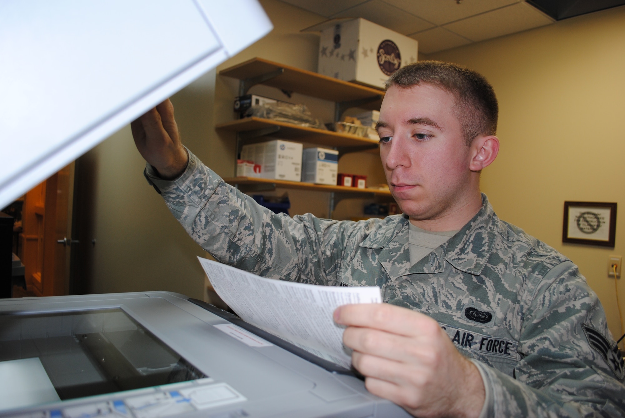 Senior Airman Michael Murphy from the 69th Reconnaissance Group makes copies of privacy act statement at his work section Dec. 13, 2013, on Grand Forks Air Force Base, N.D. As an information assurance officer, Murphy ensures documents are properly labeled and handled as part of his daily duties. (U.S. Air Force photo/Staff Sgt. Luis Loza Gutierrez) 