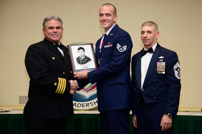 U.S. Navy Capt. Timothy Sparks, Joint Base Charleston deputy commander, and Chief Master Sgt. Shawn Hughes, 437th Airlift Wing command chief, present Staff Sgt. Matthew Branther, 14th Weather Squadron  weather forecaster, the John Levitow Award during the Airman Leadership School Class 14-A graduation ceremony Dec. 12, 2013, at JB Charleston - Air Base, S.C. The Levitow Award is awarded for a student's exemplary demonstration of excellence, both as a leader and scholar. (U.S. Air Force photo/Tech. Sgt. Rasheen Douglas)