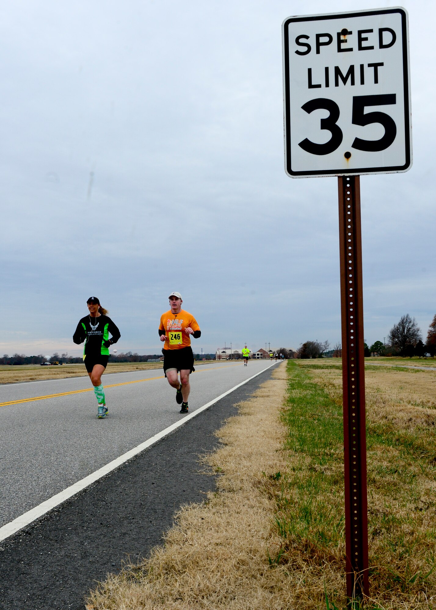 Two runners attempt to stay under the 35 mph speed limit during the 4th annual “Race 'Round the Base” at Langley Air Force Base, Va., Dec. 14, 2013.  More than 40 volunteers served as road-guards and manned water stations. (U.S. Air Force photo by Staff Sgt. John D. Strong II/Released) 