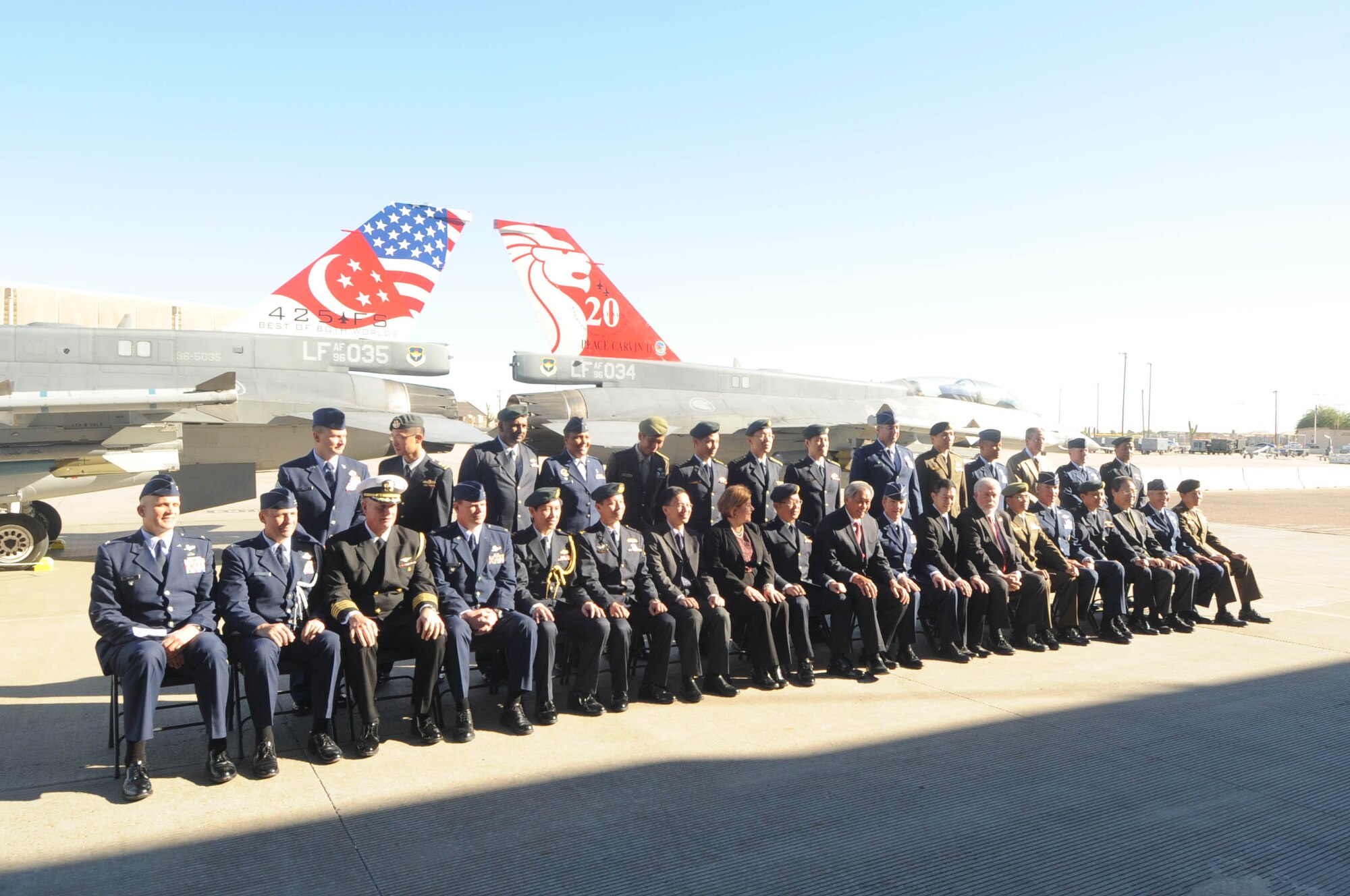 Leadership from the U.S. and Singapore air forces pose for a group photo in front of two F-16s with newly painted tail flashes Dec. 11 at Luke Air Force Base, Ariz., at the Peace Carvin II Parade. The event commemoratedthe Republic of Singapore Air Force’s 20 years of partnership with the USAF at Luke AFB. (U.S. Air Force photo by Staff Sgt. Luther Mitchell Jr.)