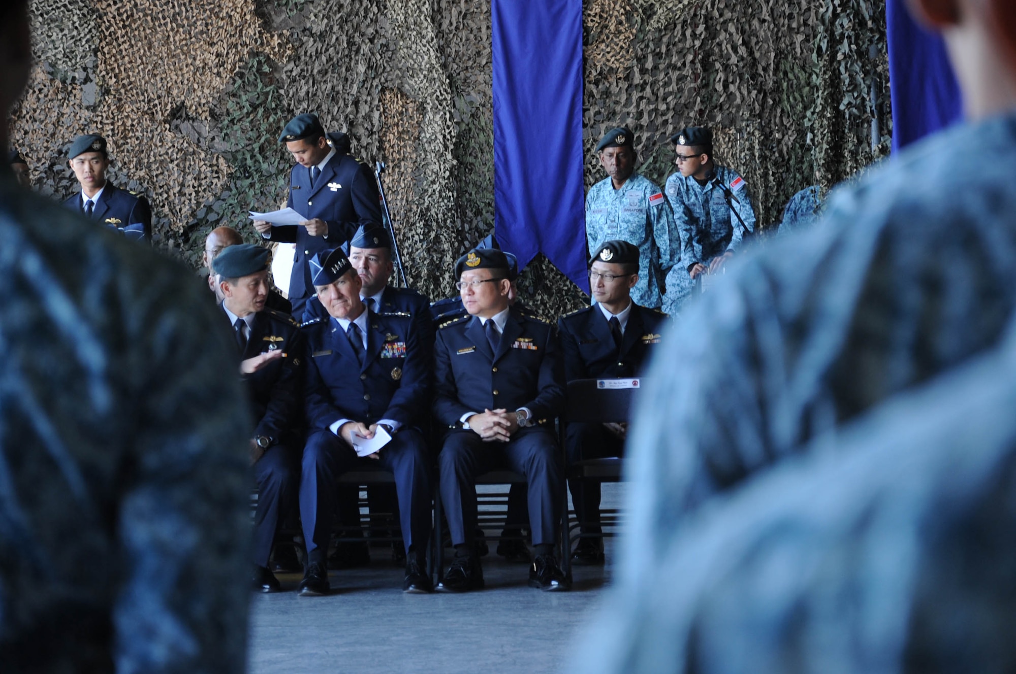 Gen. Hawk Carlisle, Pacific Air Forces commander, listens to a Republic of Singapore Air Force member during the Peace Carvin II Parade Dec. 11 at Luke Air Force Base, Ariz. Carlisle and Maj. Gen. Hoo Cher Mou, Republic of Singapore chief of air force, unveiled the newly-painted tail flashes of the U.S. Air Forc and Republic of Singapore Air Force F-16s at the end of the parade, which commemorated 20 years of partnership between the Republic of Singapore Air Force and the U.S. Air Force.. (U.S. Air Force photo by Staff Sgt. Luther Mitchell Jr.)