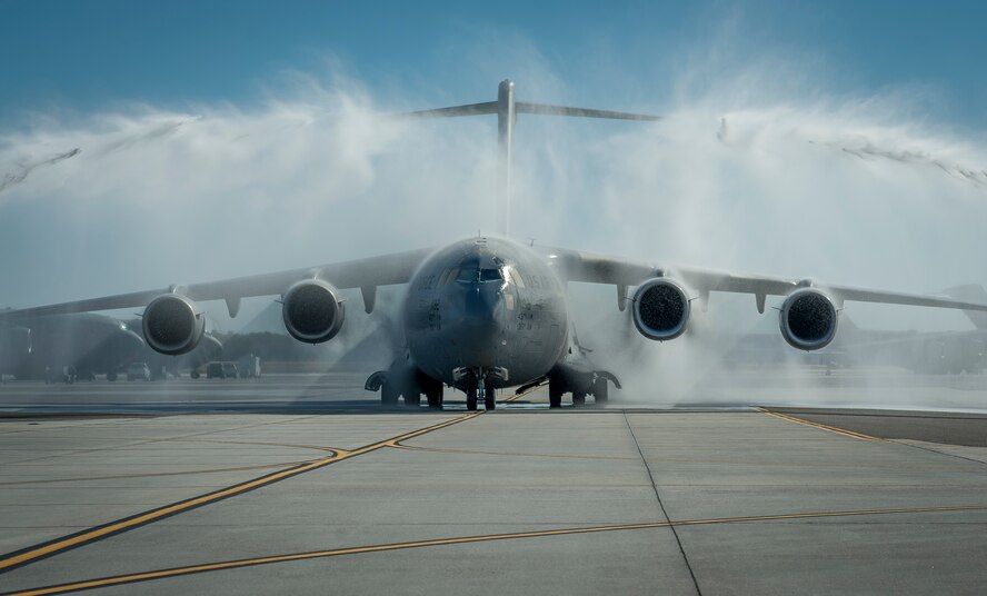 Water hoses welcome the “Spirit of Charleston” C-17 Globemaster III as it taxis in after successfully logging more than 20,000 flight hours Dec. 18, 2013, at Joint Base Charleston – Air Base, S.C. The Spirit of Charleston was the first C-17 in the U.S. Air Force’s inventory and has flown missions throughout the world for more than two decades. (U.S. Air Force photo / Senior Airman Tom Brading) 

