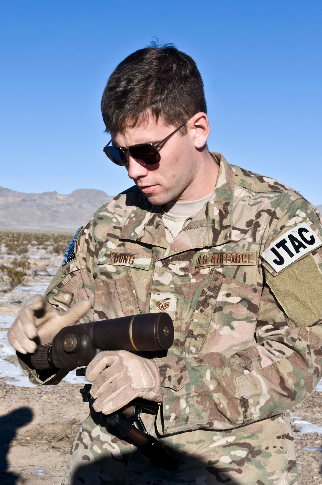 U.S. Air Force Staff Sgt. Christopher Young, 605th Test and Evaluation Squadron joint terminal attack controller, sets up equipment during a Handheld Laser Marker Tactics Development and Evaluation project Dec. 11, 2013, at the Nevada Test and Training Range. The objective of the test is to provided data for decision makers to decide whether or not to allow the LA-10u/PEQ handheld laser marker to be used as a laser designator. As a laser designator it will be able to guide munitions to its intended target. (U.S. Air Force photo by Senior Airman Matthew Lancaster)