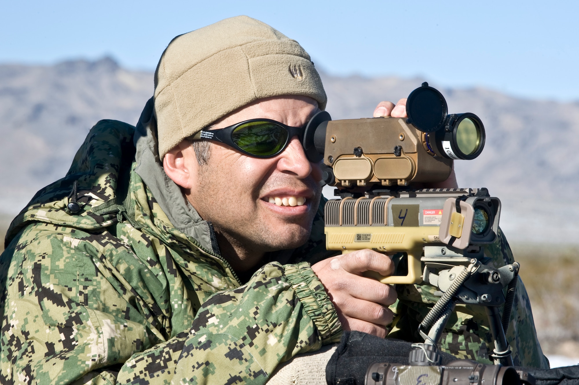 U.S. Navy Chief Petty Officer Carlos Vargas, Naval Special Warfare combatant crewman, bore sights an LA-10u/PEQ handheld laser marker during a Handheld Laser Marker Tactics Development and Evaluation project Dec. 10, 2013, at the Nevada Test and Training Range. The handheld laser marker is a small, lightweight device that emits NATO Band I/II compatible coded laser energy to quickly mark and handoff targets for engagement with precision guided munitions. (U.S. Air Force photo by Senior Airman Matthew Lancaster)