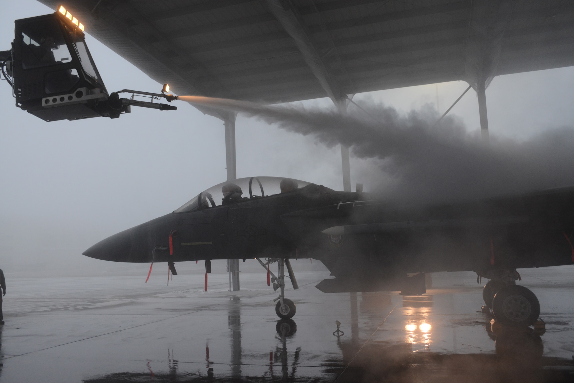 Airmen from the 366th Aircraft Maintenance Squadron de-ice an F-15E Strike Eagle Dec. 18, 2013, at Mountain Home Air Force Base, Idaho. Freezing temperatures made Airmen add a few steps into their routine in an effort to get the jets in the air. (U.S. Air Force photo by Senior Airman Benjamin Sutton/Released)