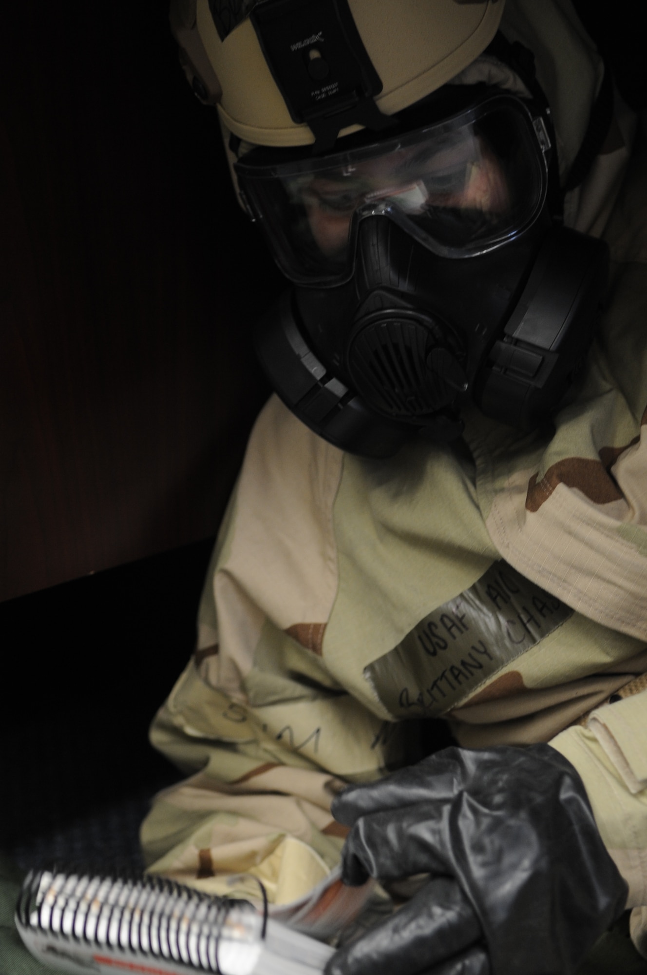 Air Force Airman 1st Class Brittany Chase, 366th Fighter Wing, studies responses in her Airman’s Manual, while in ‘MOPP 4’ during a readiness exercise at Mountain Home Air Force Base, Idaho, Dec. 18, 2013. May and other Airmen practiced attack responses, operating in a chemical environment, self-aid and buddy care techniques and other ‘deployment’ proficiencies during the training. (U.S. Air Force photo by Master Sgt. Kevin Wallace/RELEASED)