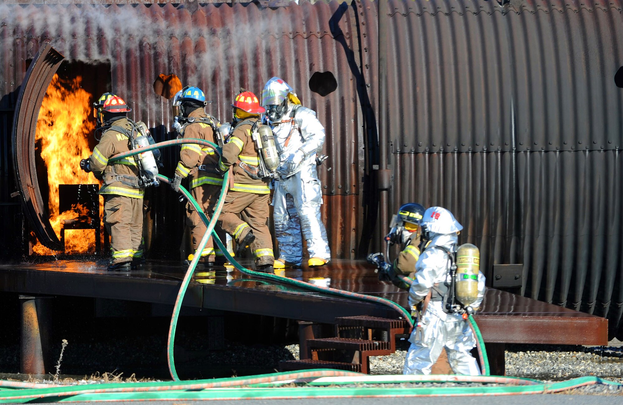 Fire firefighters work to suppress a simulated interior fire on a mock C-17 aircraft during a joint training session between Macon-Bibb County and Robins Air Force Base Fire Departments Wednesday. The training helps firefighters maintain their accreditation and provides an opportunity for members of both departments to build valuable working relationships. (U.S. Air Force photo by Tommie Horton)