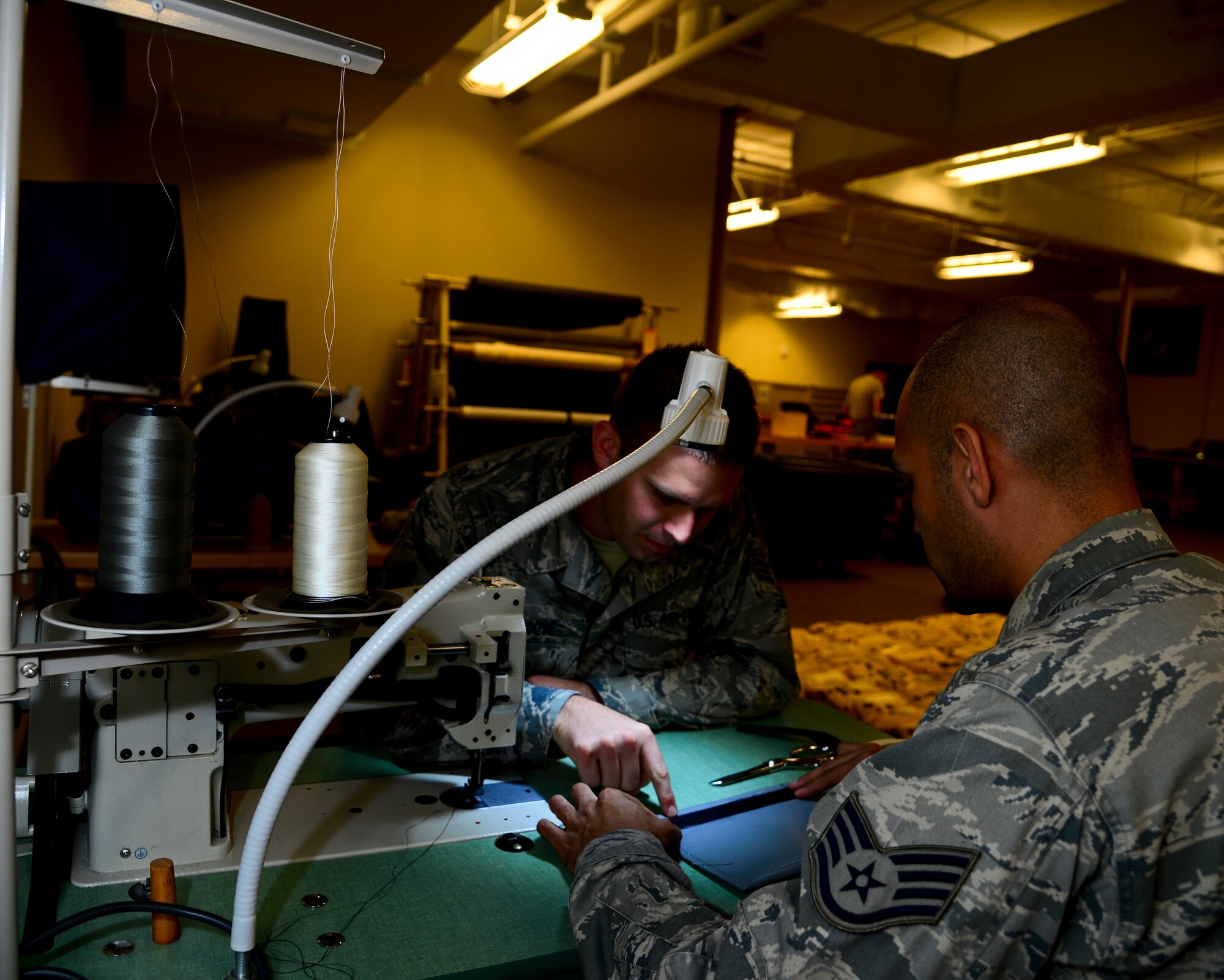 Staff Sgt. Antonio E. Vallecillo, 6th Operations Support Squadron aircrew flight equipment oxygen section supervisor, conducts on-the–job-training with Senior Airman Taylor Clouse, 927th Air Refueling Wing AFE technician, Nov 20, 2013 at MacDill Air Force Base, Fla. AFE Airmen repair  fabric and rubber components, including protective clothing, thermal radiation barriers, flotation equipment and various parachutes. (U.S. Air Force photo by Senior Airman Melanie Bulow-Gonterman/Released)   
